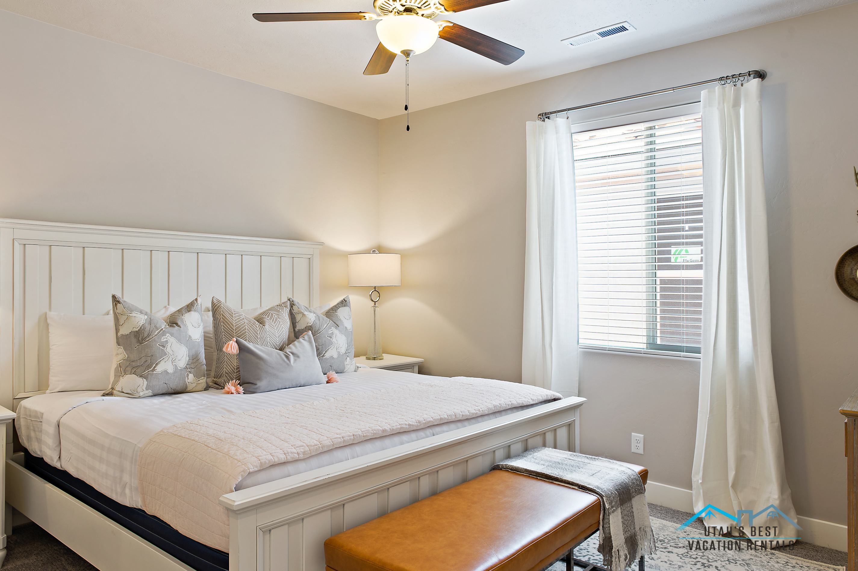Spacious room with a window featuring blinds and light-filtering drapes