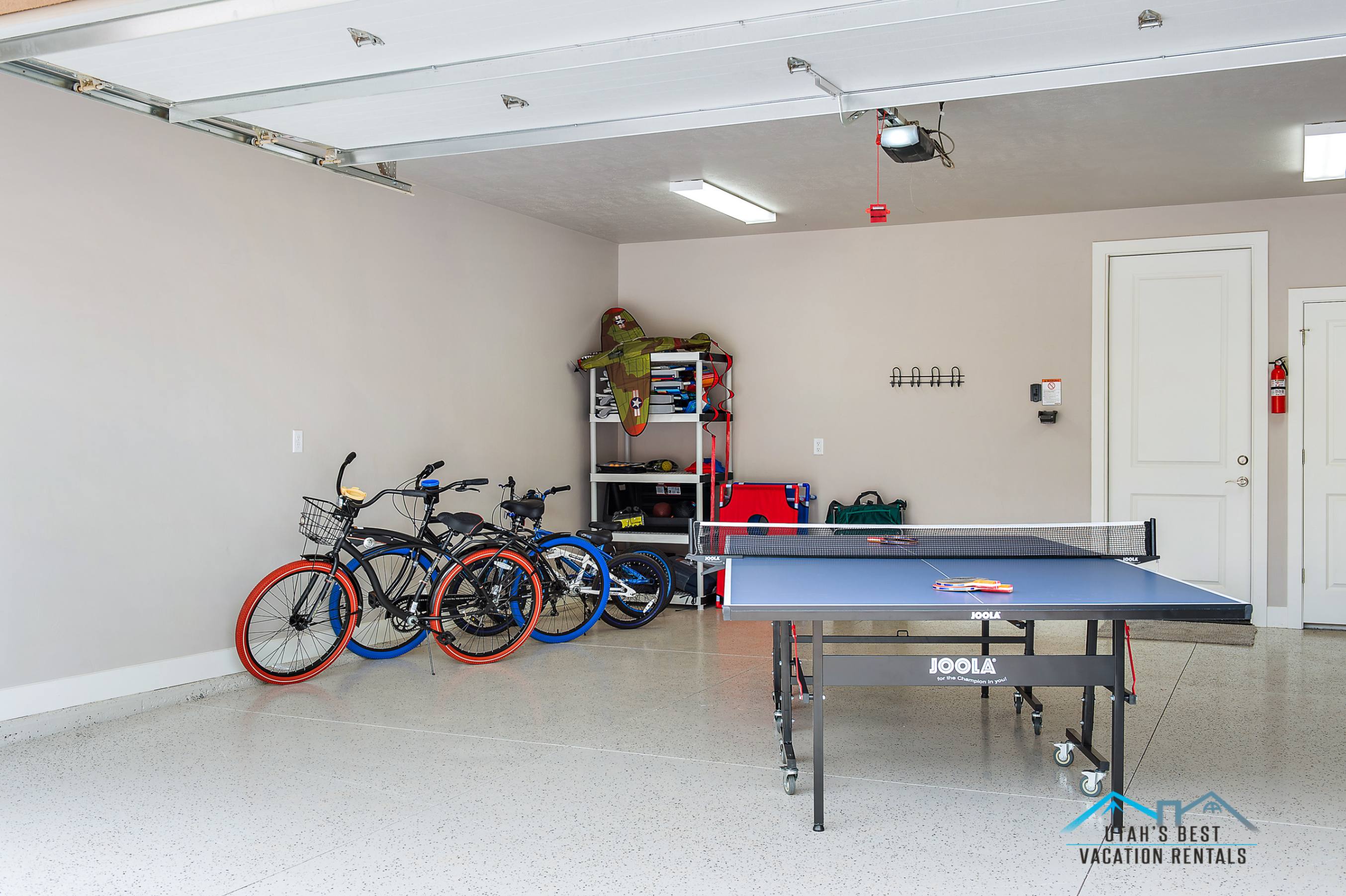 Spacious garage featuring a durable epoxy floor, overhead fluorescent lighting, and two panel doors