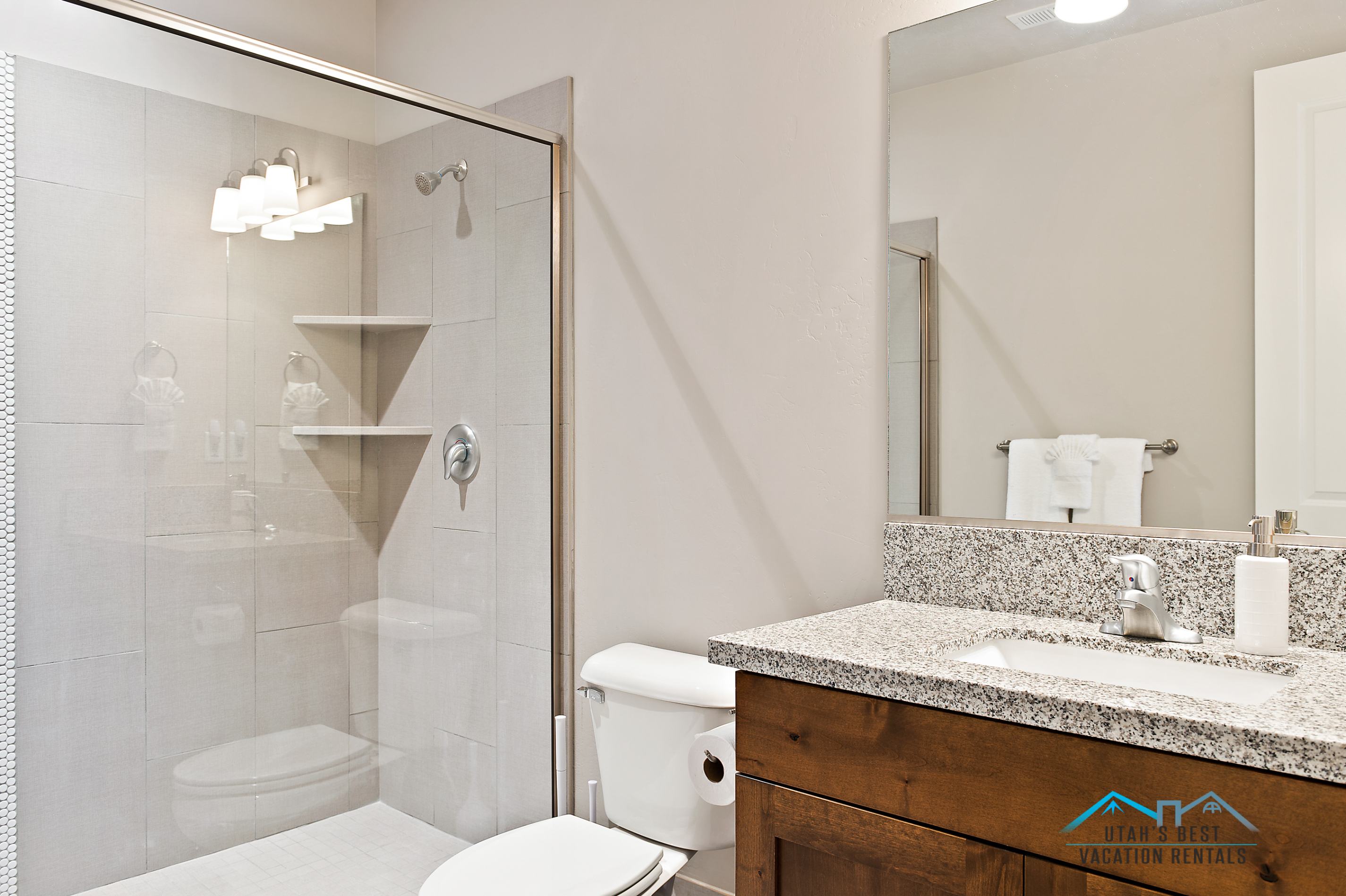 Bathroom featuring a glass-enclosed shower with tile surround and integrated corner shelving