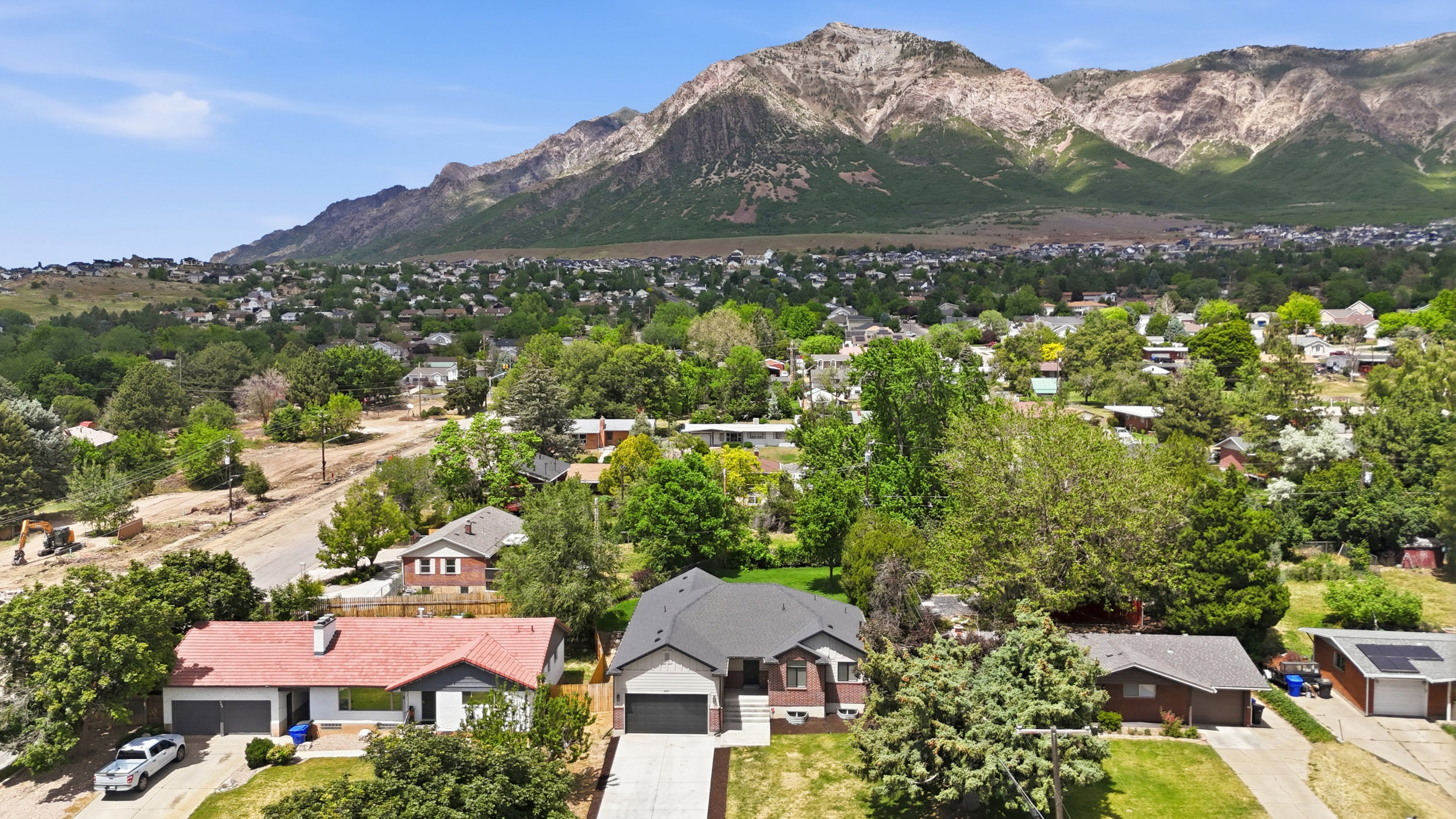 Expansive mountain backdrop framing a residential neighborhood with mature trees