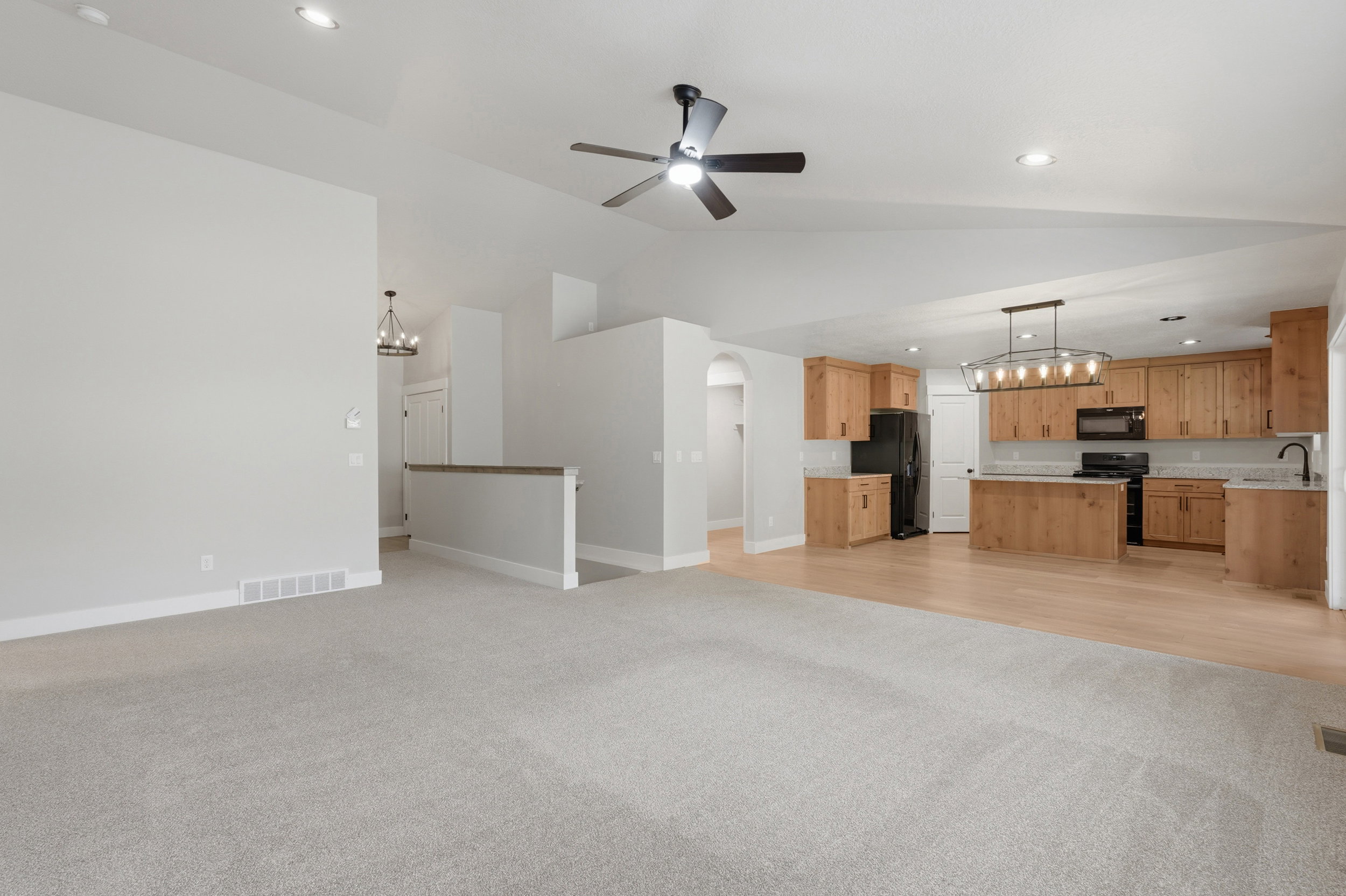 Open-concept living area featuring vaulted ceilings, recessed lighting, and a contemporary ceiling fan