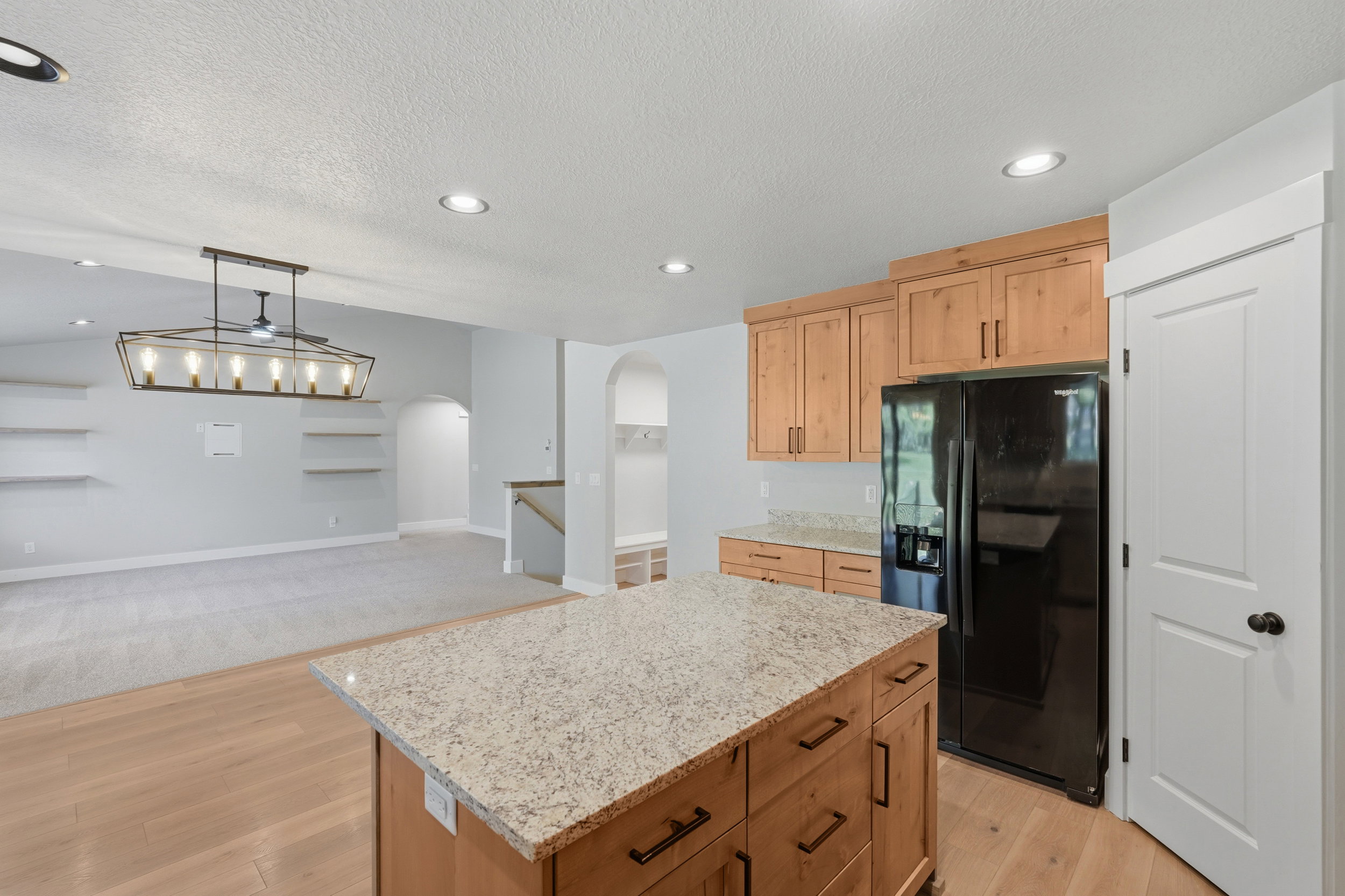 Kitchen island featuring a granite countertop and wood cabinetry