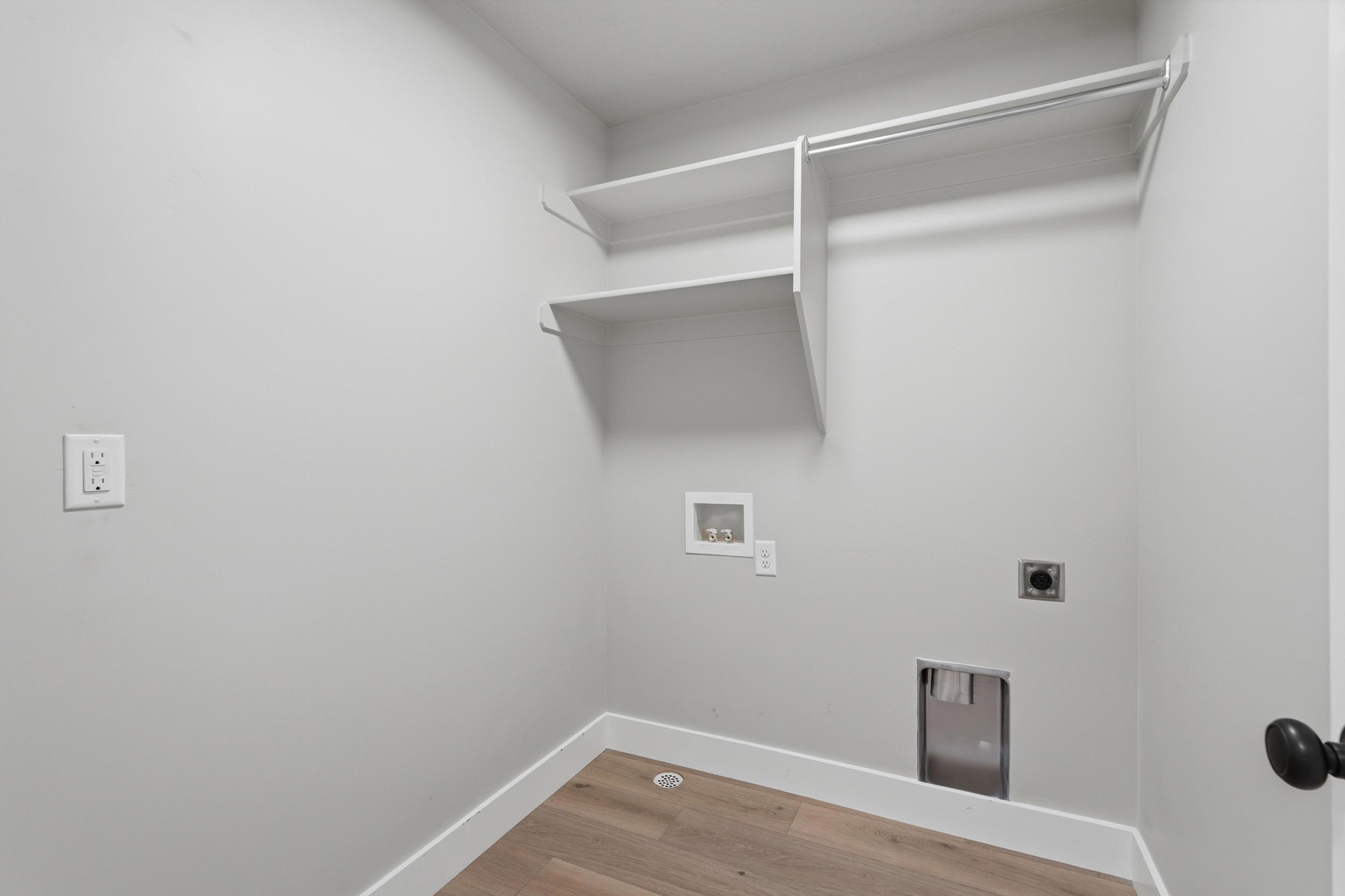 Dedicated laundry area featuring built-in shelving.