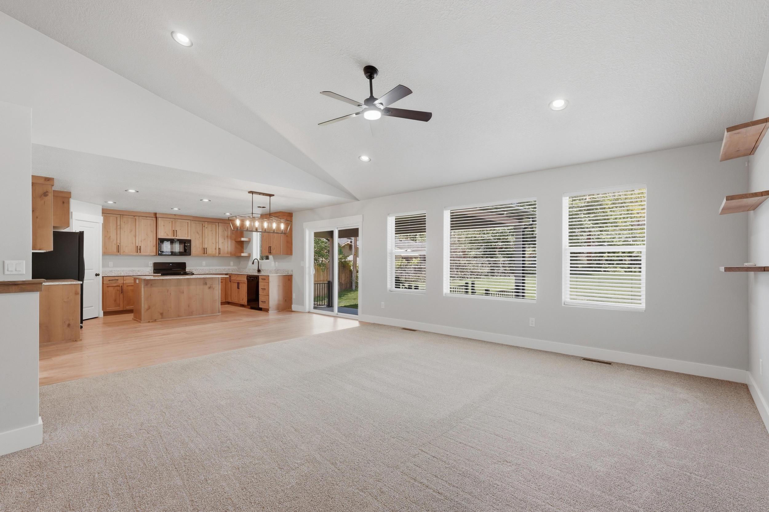 Open-concept living area with vaulted ceilings and recessed lighting