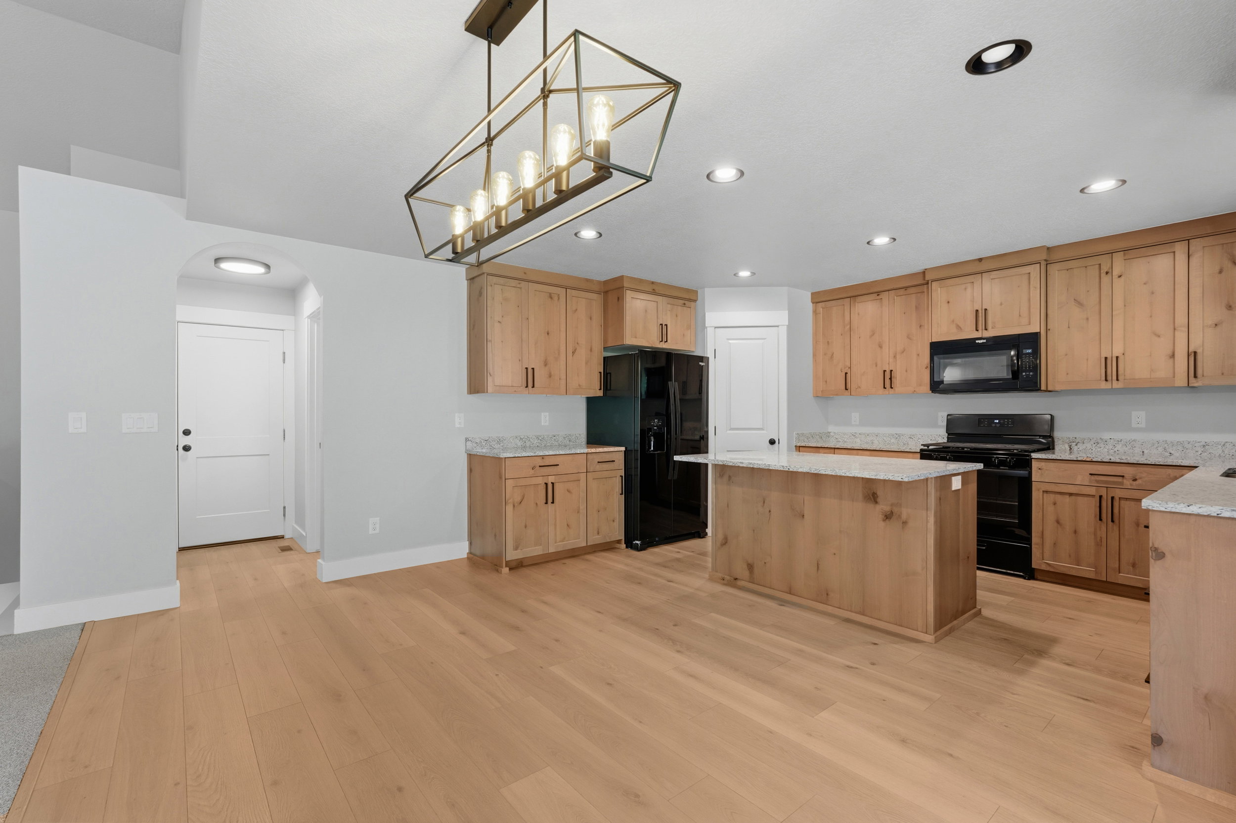 Open-concept kitchen and dining area featuring wood-finish flooring