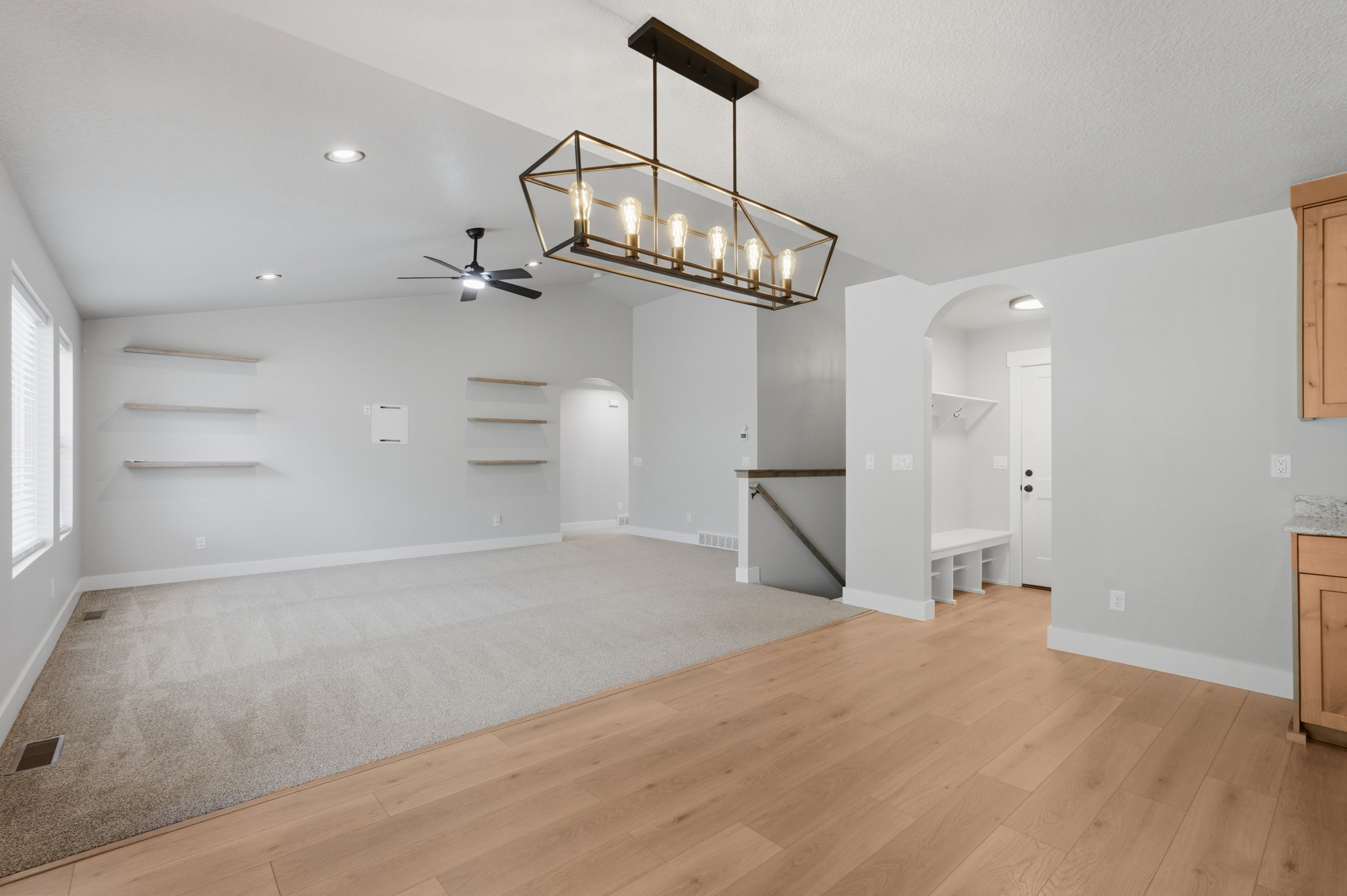 Spacious living area featuring vaulted ceilings, recessed lighting, and a contemporary linear chandelier
