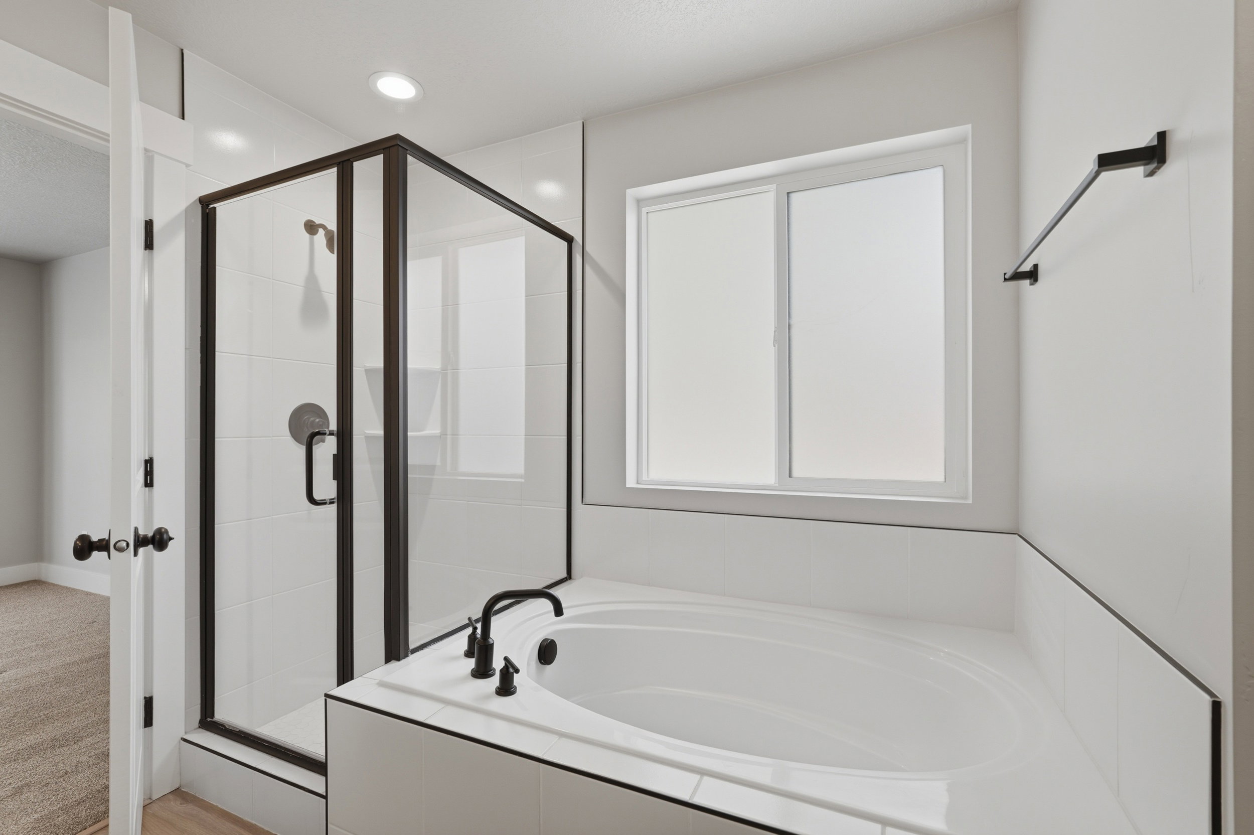 Primary bedroom ensuite bathroom featuring a built-in soaking tub and enclosed shower.