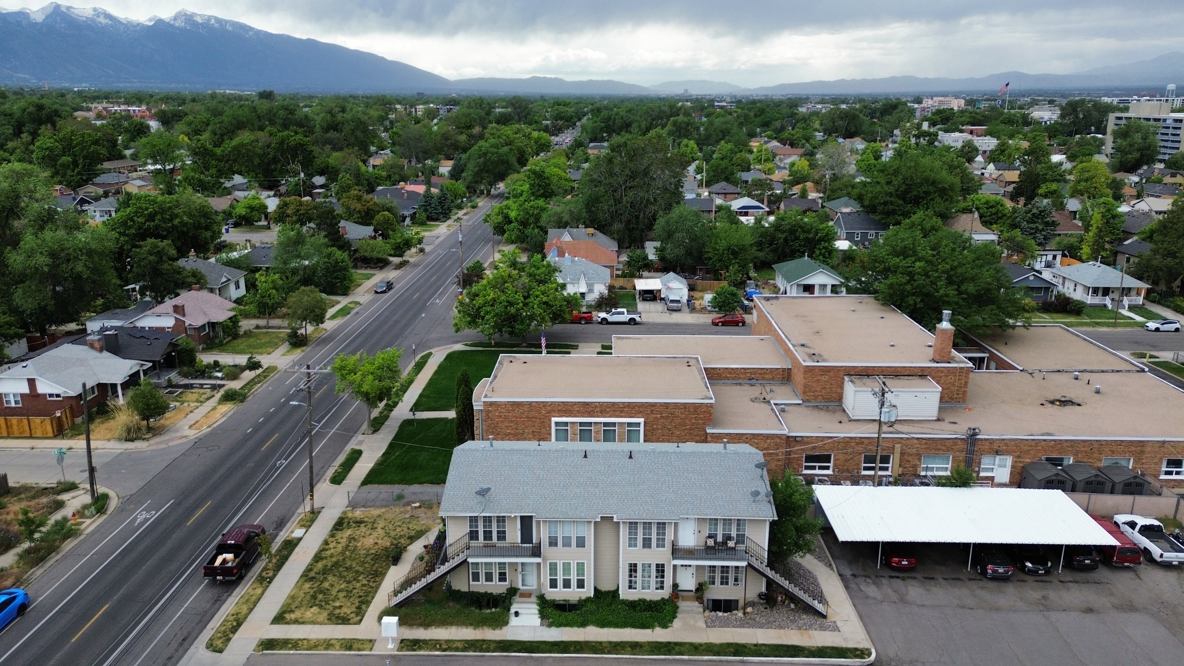 Aerial perspective showcasing a multi-unit property with a light gray roof and two-tone exterior siding