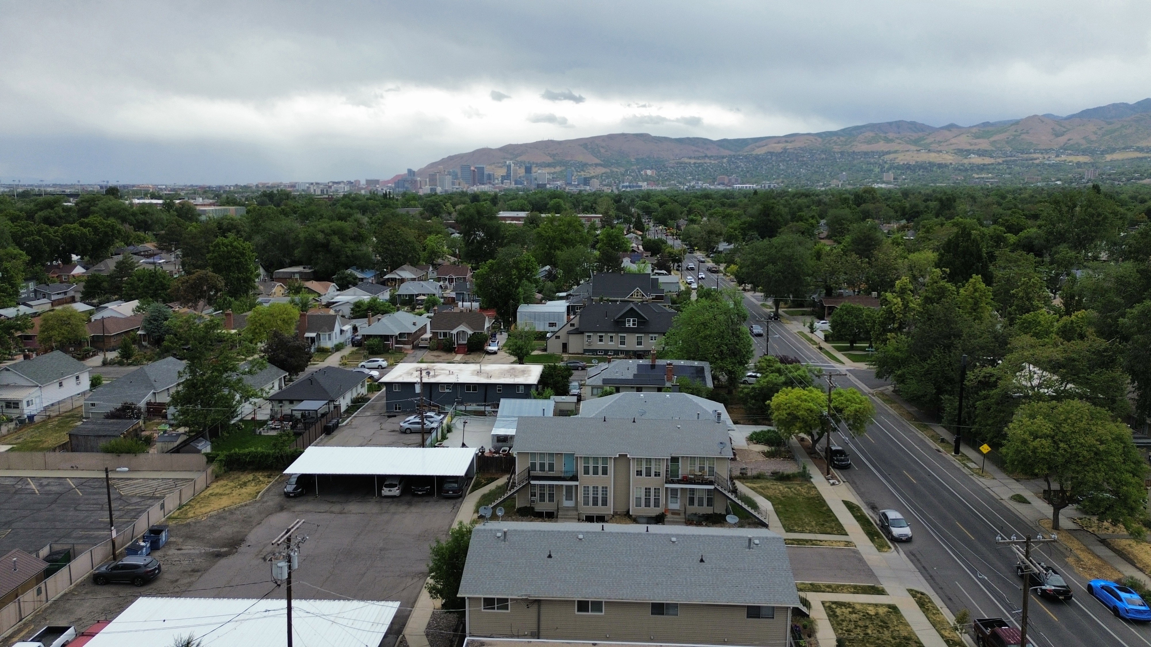 Residential structures with traditional pitched roofs, surrounded by mature trees and paved roadways
