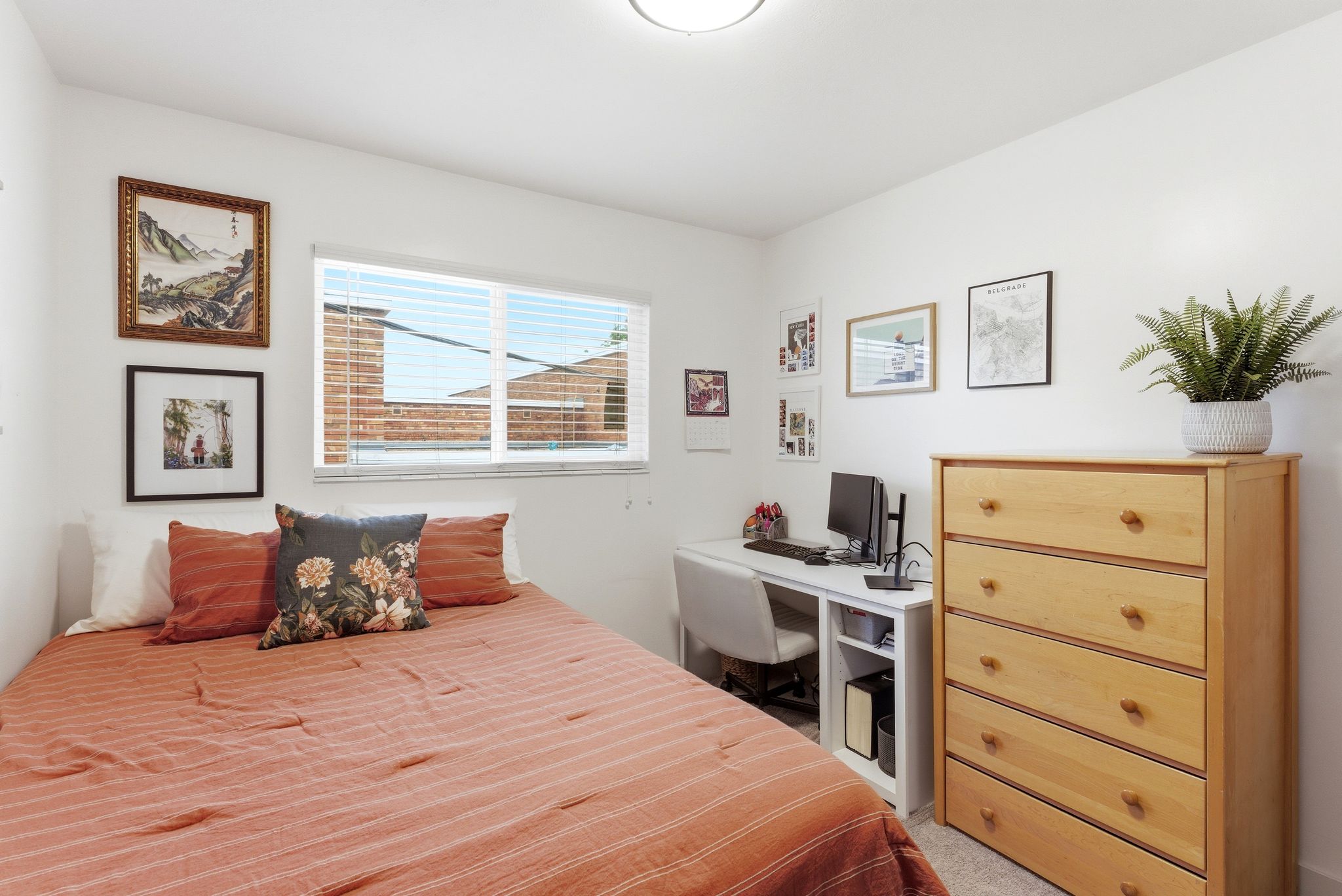 Bedroom featuring a window with blinds, light-colored walls, and a ceiling-mounted light fixture