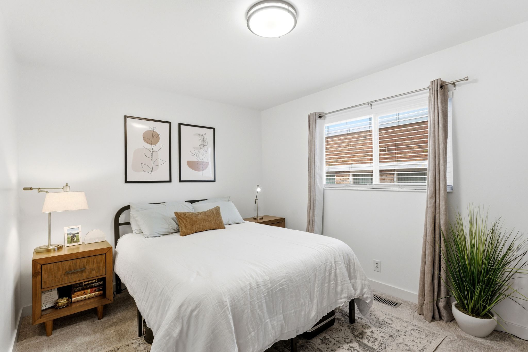 Interior room featuring a window with blinds, a ceiling-mounted light fixture, and a light-colored wall finish