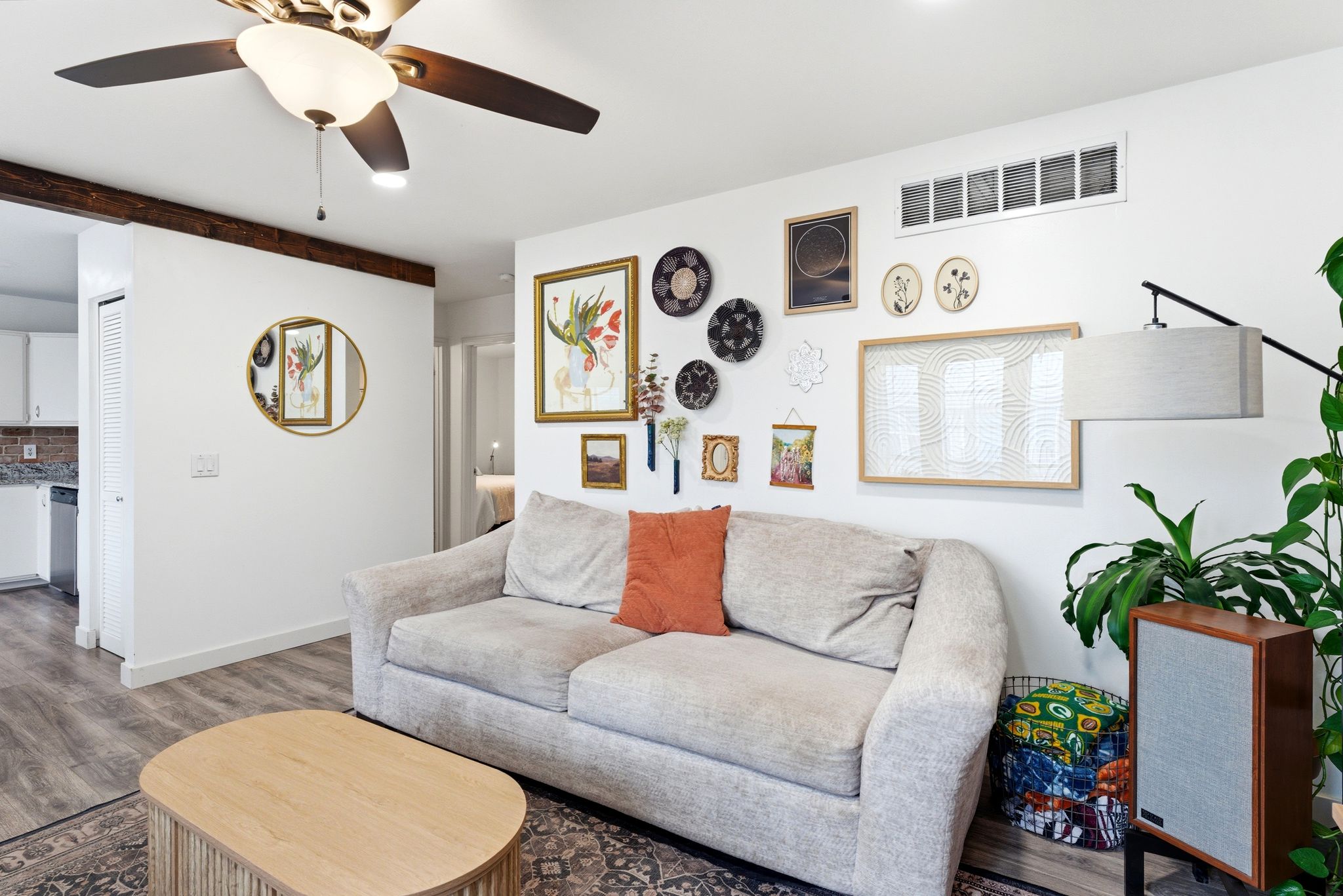 Open concept living area featuring wood-finish flooring, a ceiling fan with integrated lighting, and a white interior paint scheme