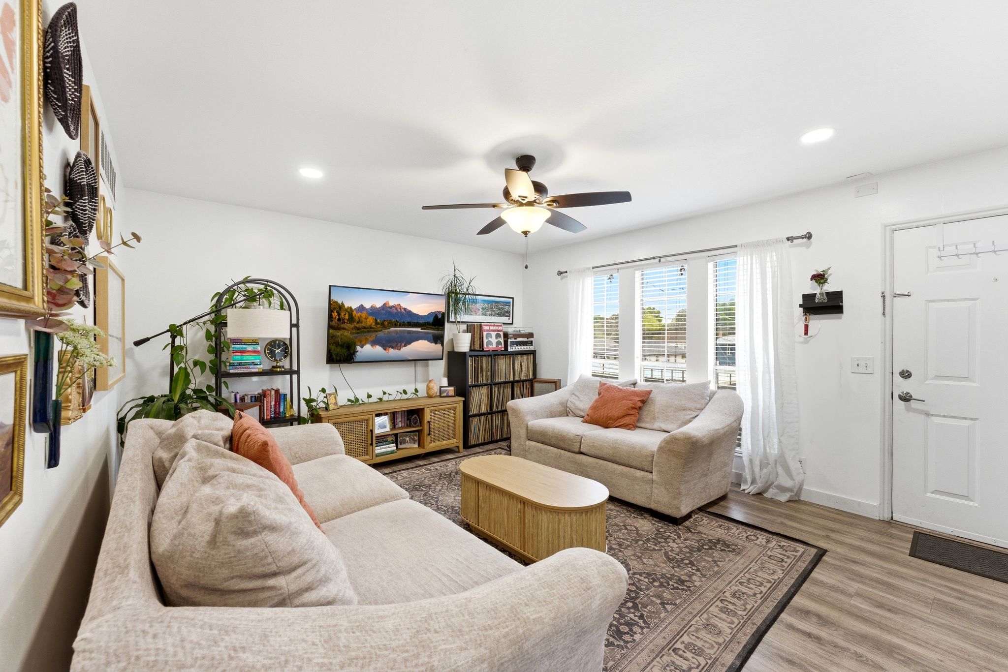 Living area featuring wood-finish flooring, a ceiling fan with integrated lighting, and recessed ceiling lights