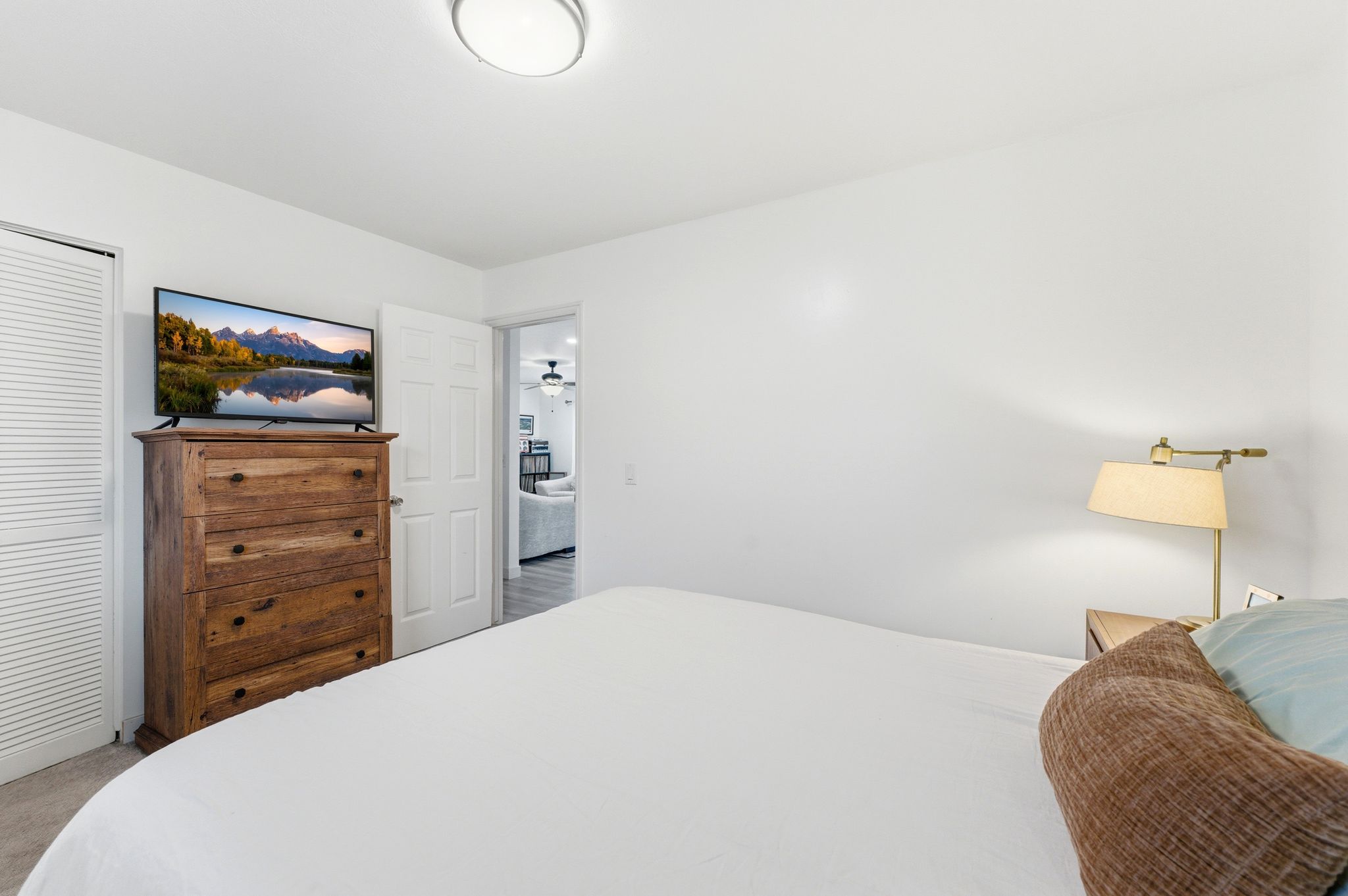 Bedroom with a flush-mount ceiling light, white walls, and carpet flooring