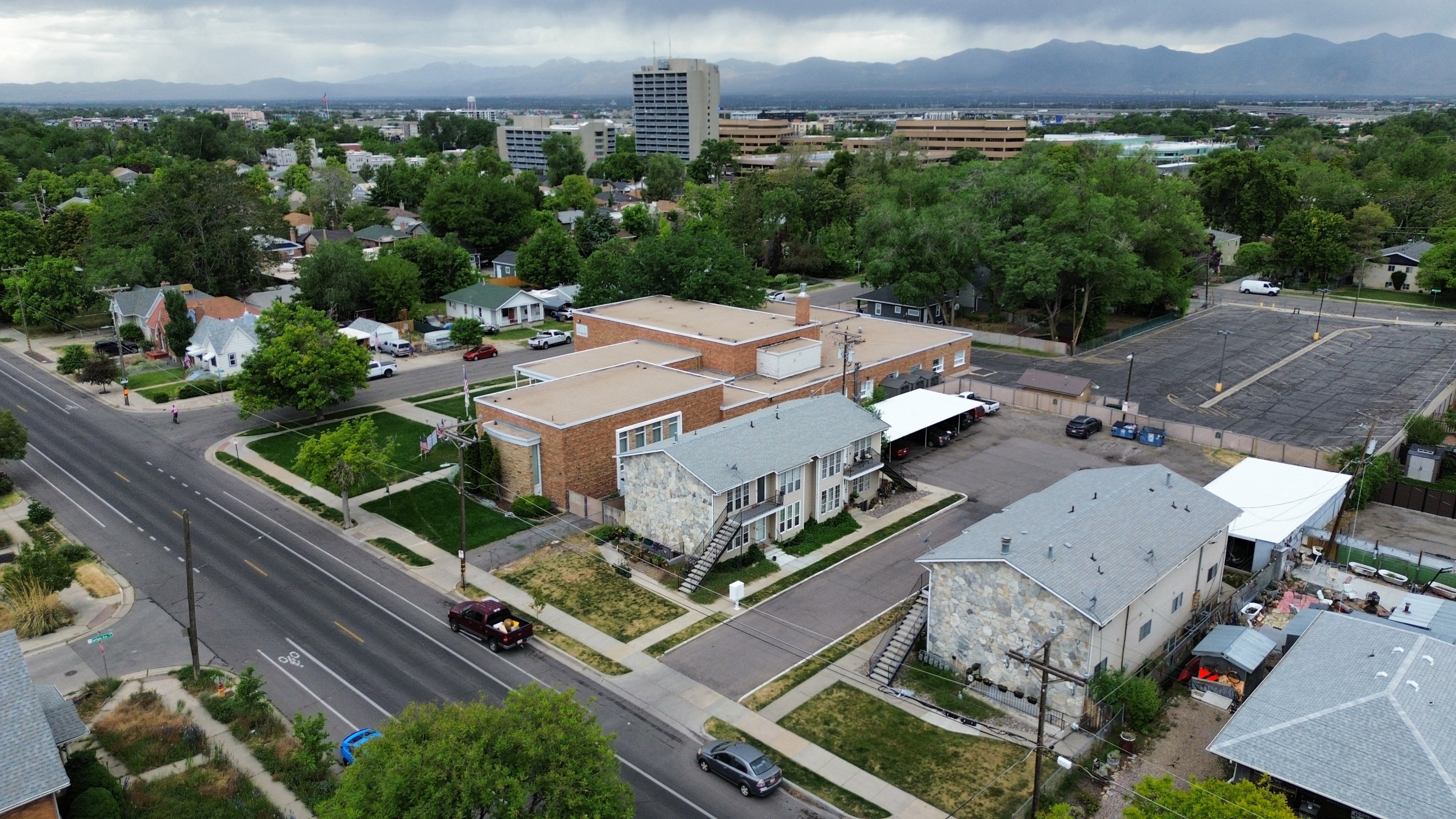 Aerial perspective showcasing an urban neighborhood with a mix of residential structures and commercial buildings