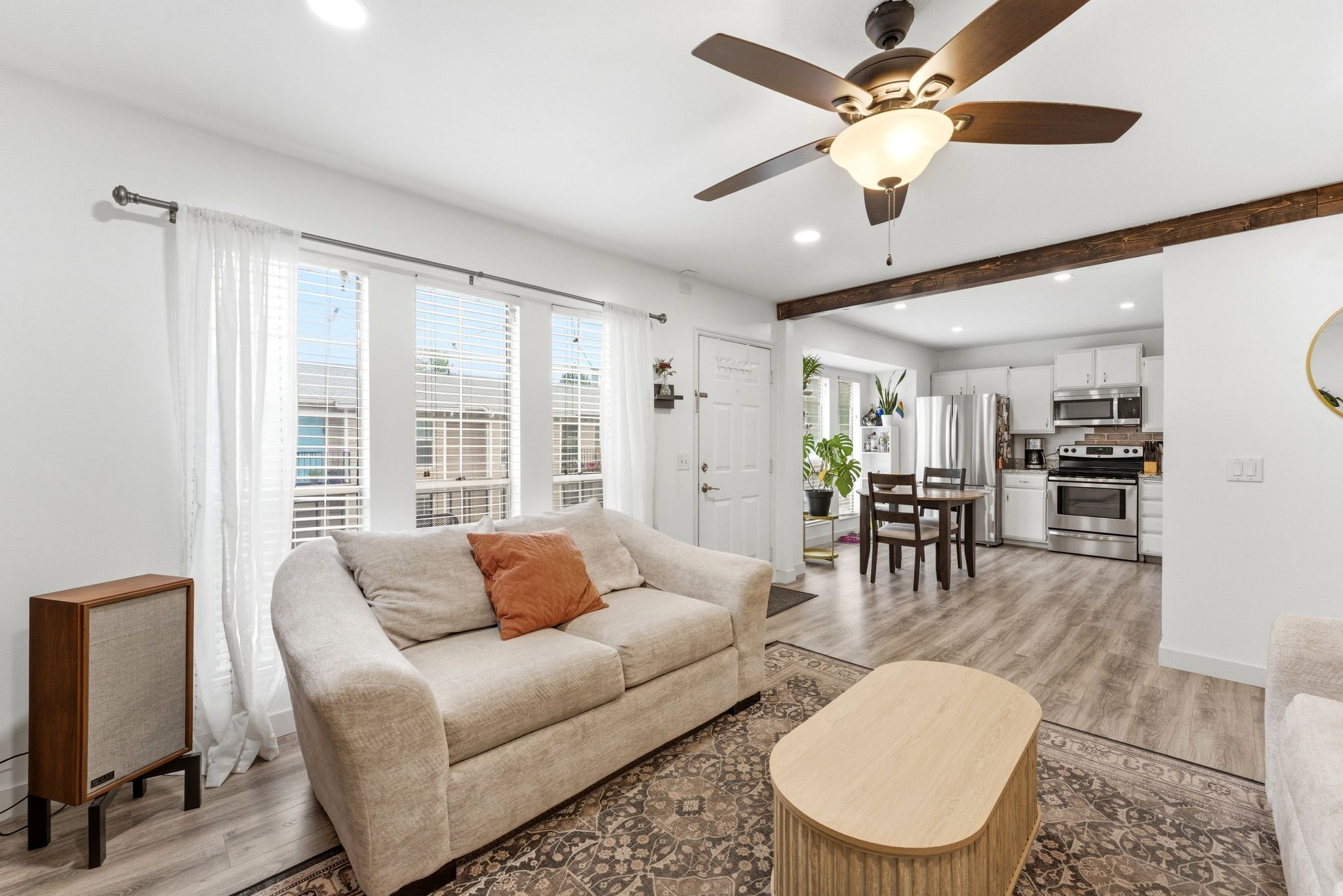 Open-concept living space with wood-finish flooring, a ceiling fan, and recessed lighting