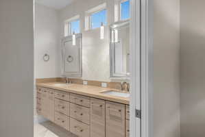 Contemporary bathroom vanity featuring dual undermount sinks set in a light-toned countertop