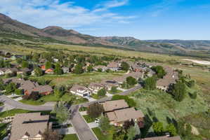Expansive aerial showcasing a residential area nestled against a mountainous backdrop