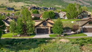 Craftsman-style residence with a two-car garage, stone and siding exterior, and a paved driveway