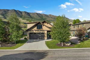 Contemporary property featuring a neutral-toned facade with stone accents and a prominent two-car garage