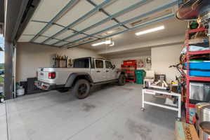 Spacious garage featuring a concrete floor, overhead lighting, and an automatic garage door opener
