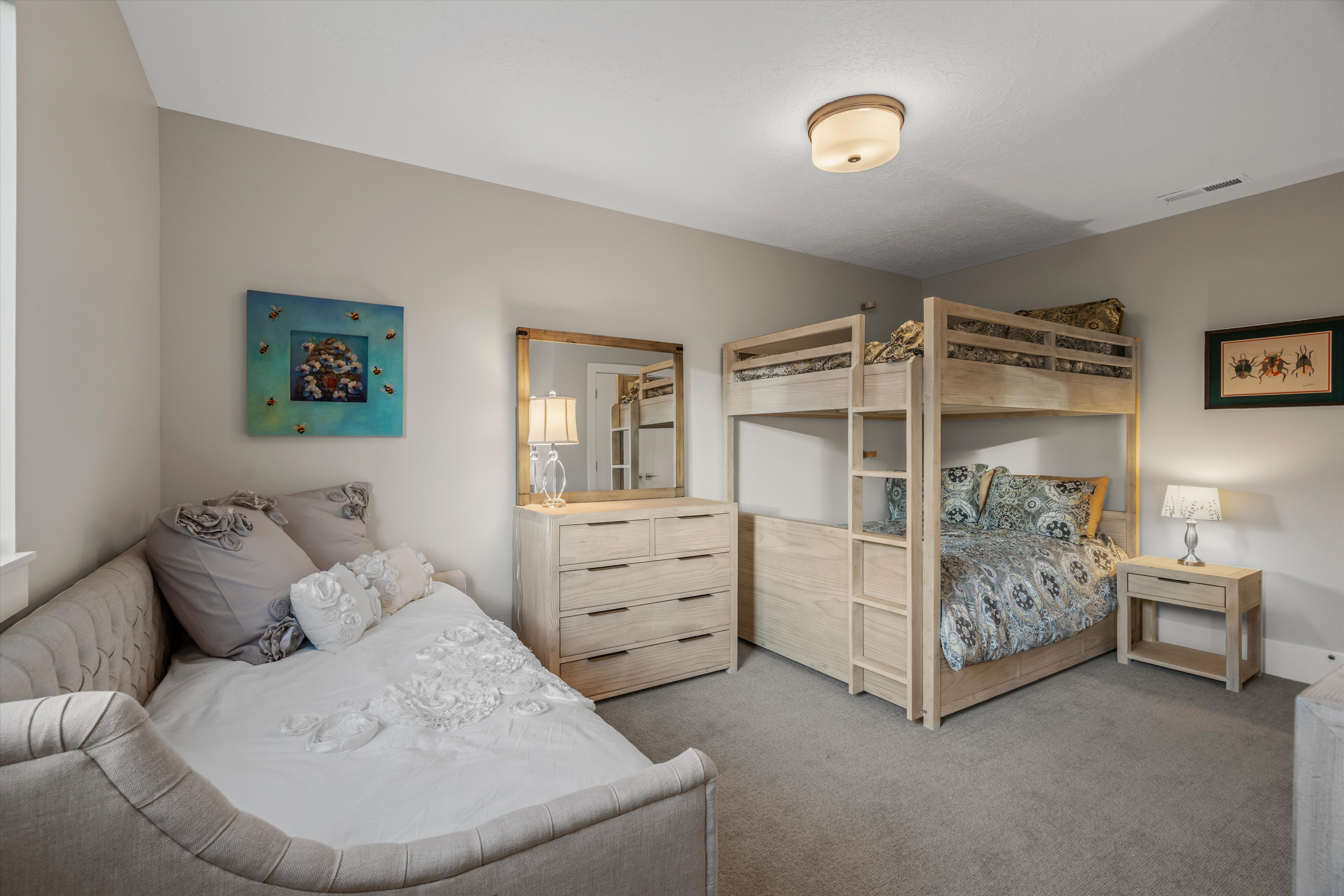 Carpeted bedroom featuring a light-toned bunk bed, a matching dresser with a mirror, and a daybed
