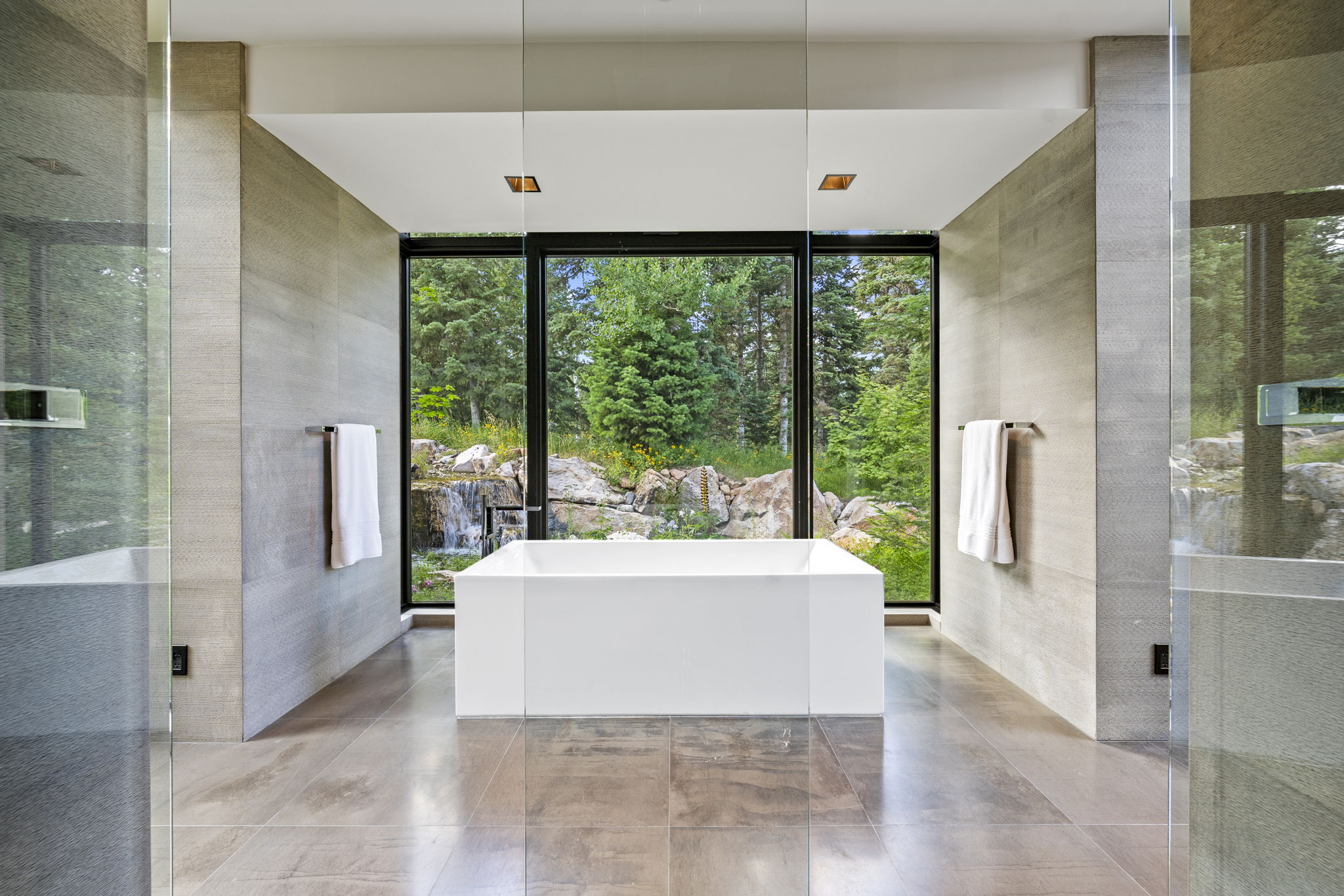 Freestanding soaking tub centered before expansive picture windows