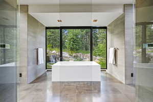 Freestanding soaking tub centered before expansive picture windows