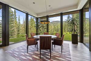 Dining area featuring a contemporary round table, wood-finish flooring, and a linear pendant light fixture