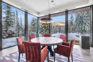 Dining area featuring expansive floor-to-ceiling windows, offering panoramic mountain scenery