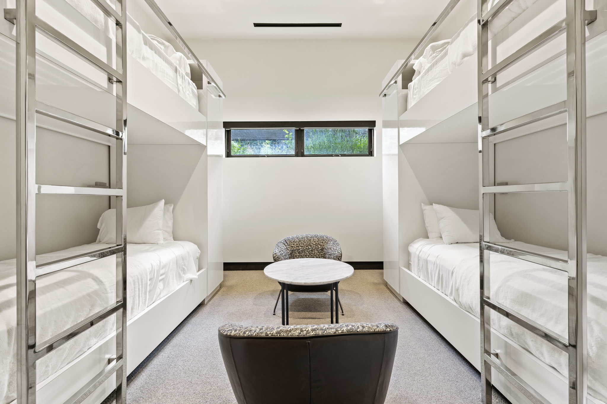 Modern bunk room featuring four built-in bunk beds with integrated ladders