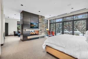 Expansive floor-to-ceiling windows overlooking a snow-covered forest