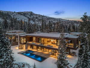 Contemporary residence featuring a multi-level design with extensive glass facade and stone accents