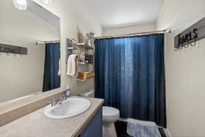 Bathroom featuring a single basin vanity with an oval sink, chrome faucet, and a light-toned countertop