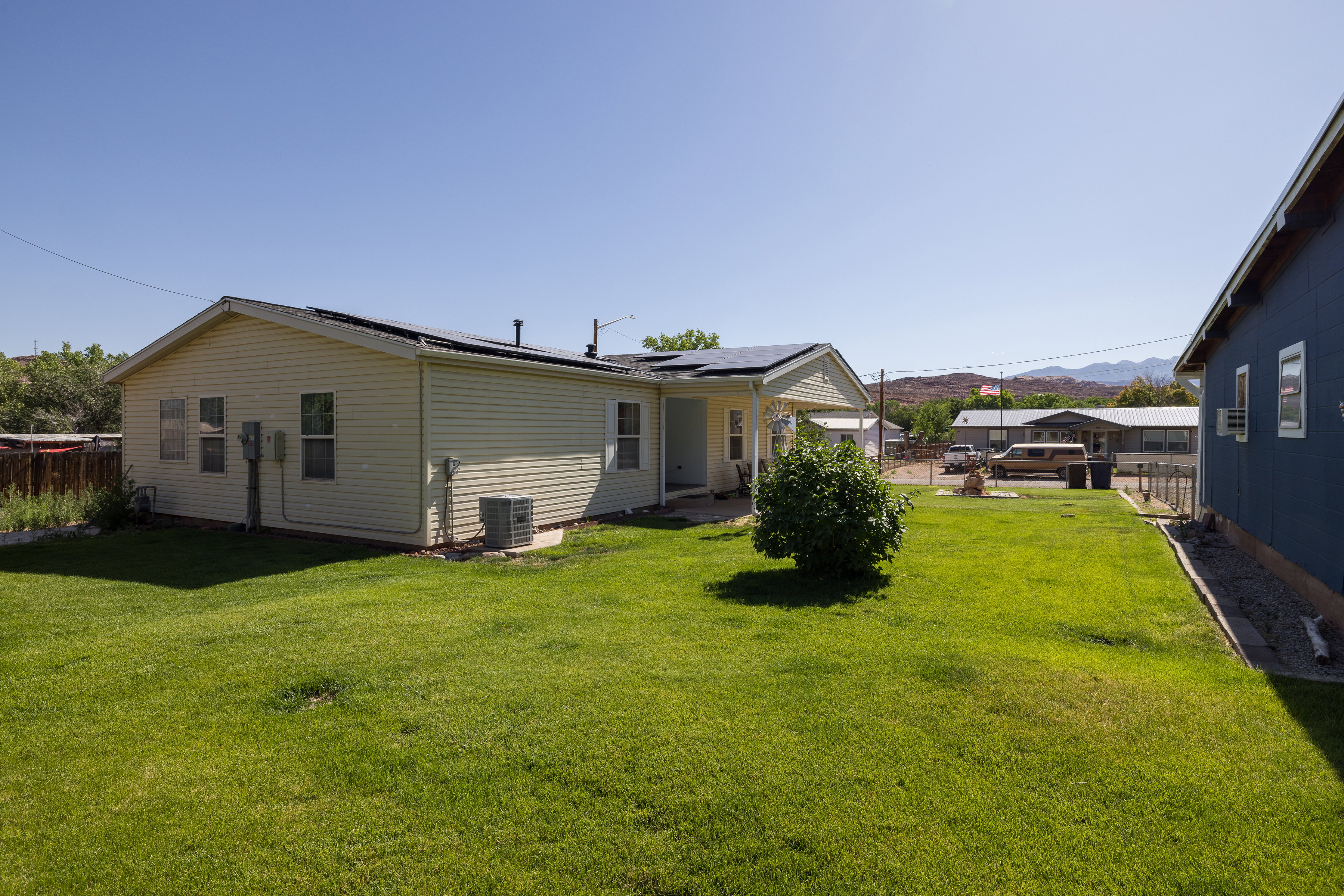 Expansive green lawn bordering a cream-colored siding residence