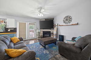 Living area featuring wood-finish flooring and a ceiling fan