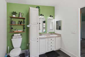 Bathroom vanity featuring dual sinks with individual mirrors, ample under-sink storage, and a tall built-in storage cabinet