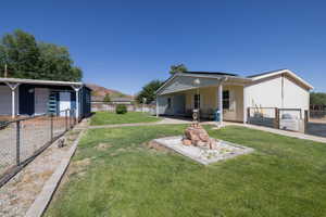 Expansive grassy yard area with a rock garden feature and concrete pathway