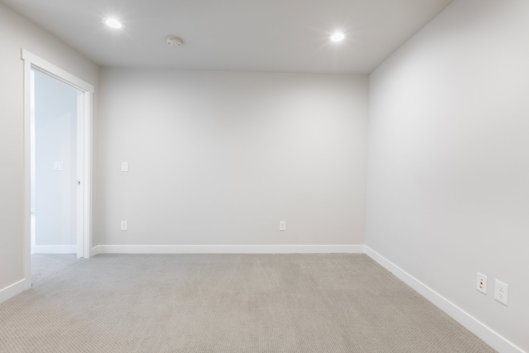 Room featuring neutral-toned carpeting, light gray walls, recessed ceiling lighting, and white baseboards