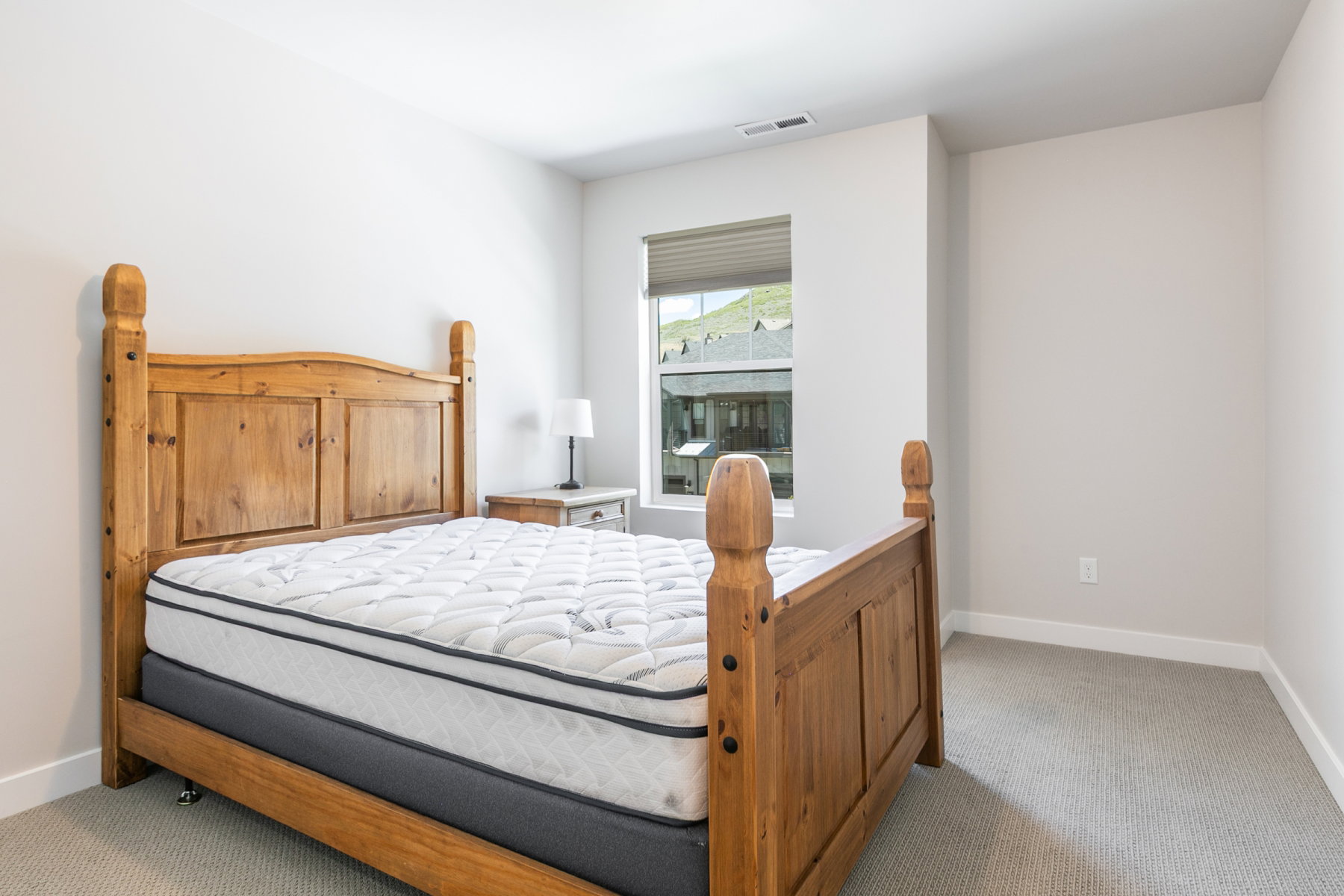 Carpeted bedroom featuring neutral wall tones and a window with blinds