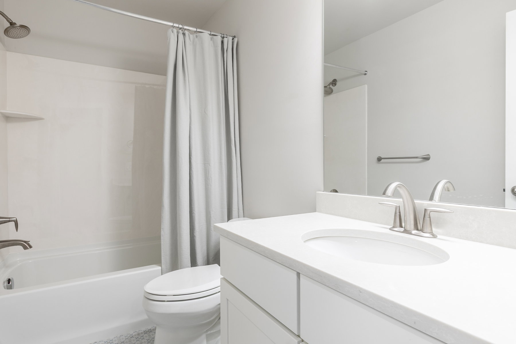 Bathroom featuring a white vanity with an undermount sink, brushed nickel faucet, and a large mirror