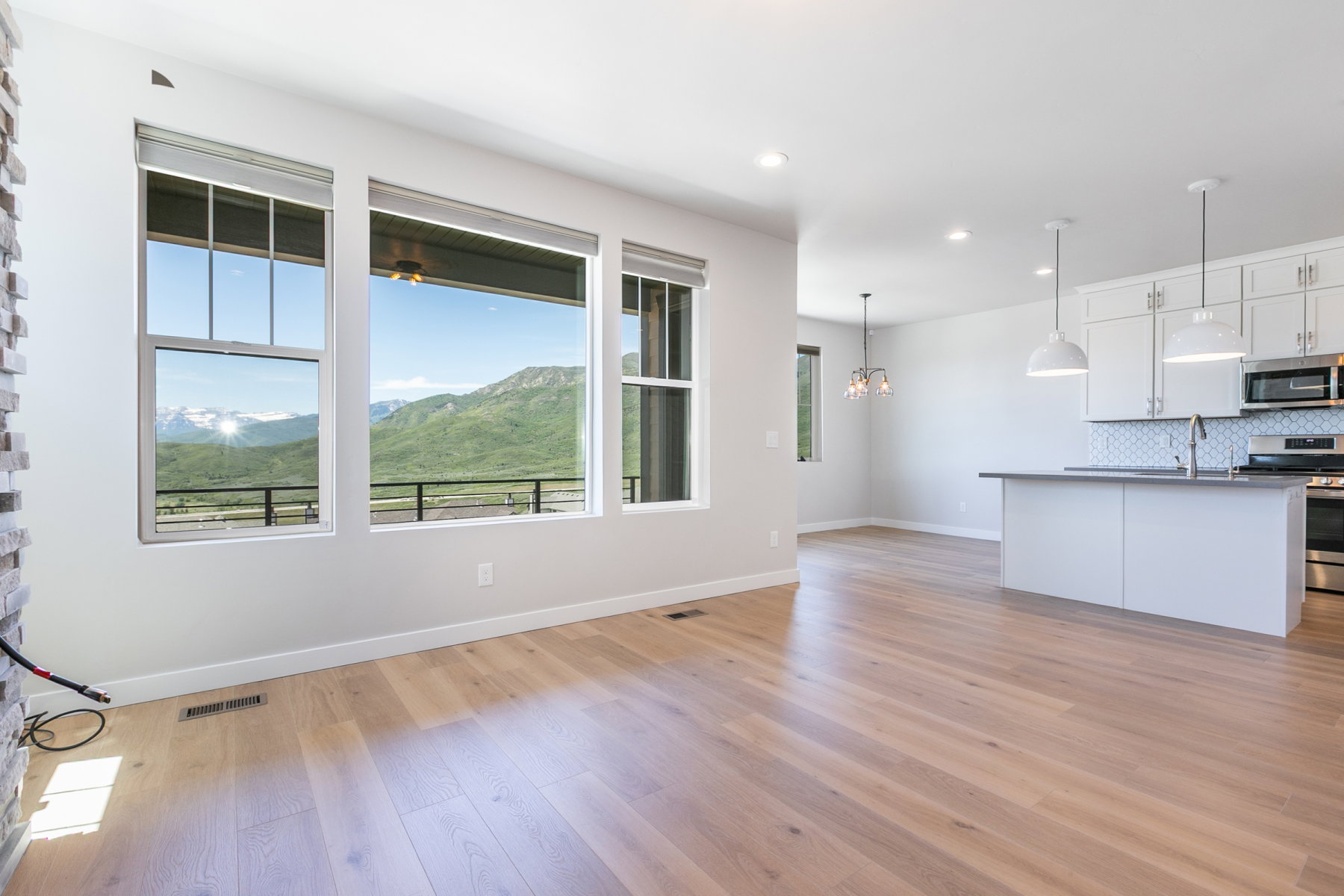 Expansive living space featuring wood-finish flooring and large windows showcasing mountain scenery
