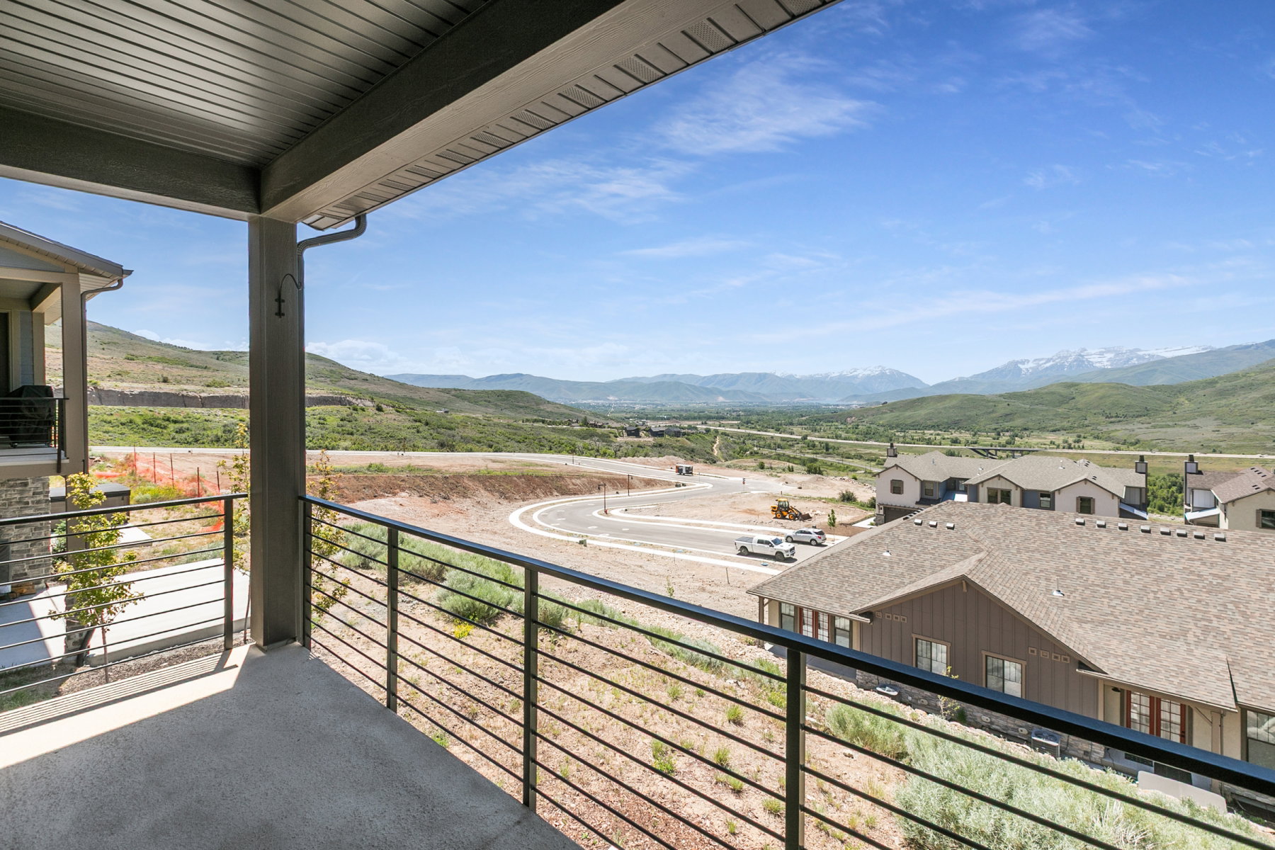 Covered patio featuring a metal railing and concrete flooring