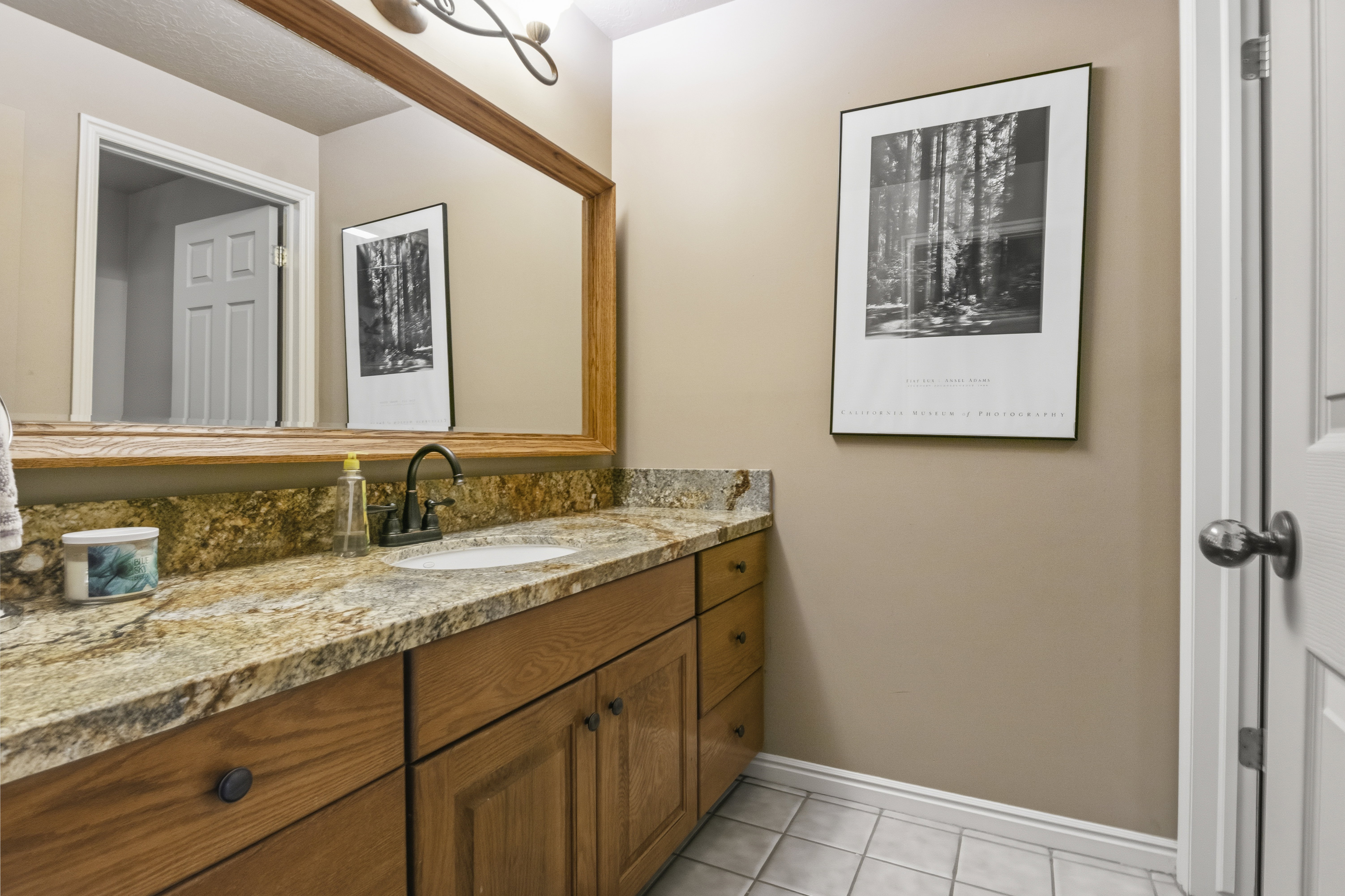 Vanity featuring a stone countertop, an integrated sink, and wood-finish cabinetry