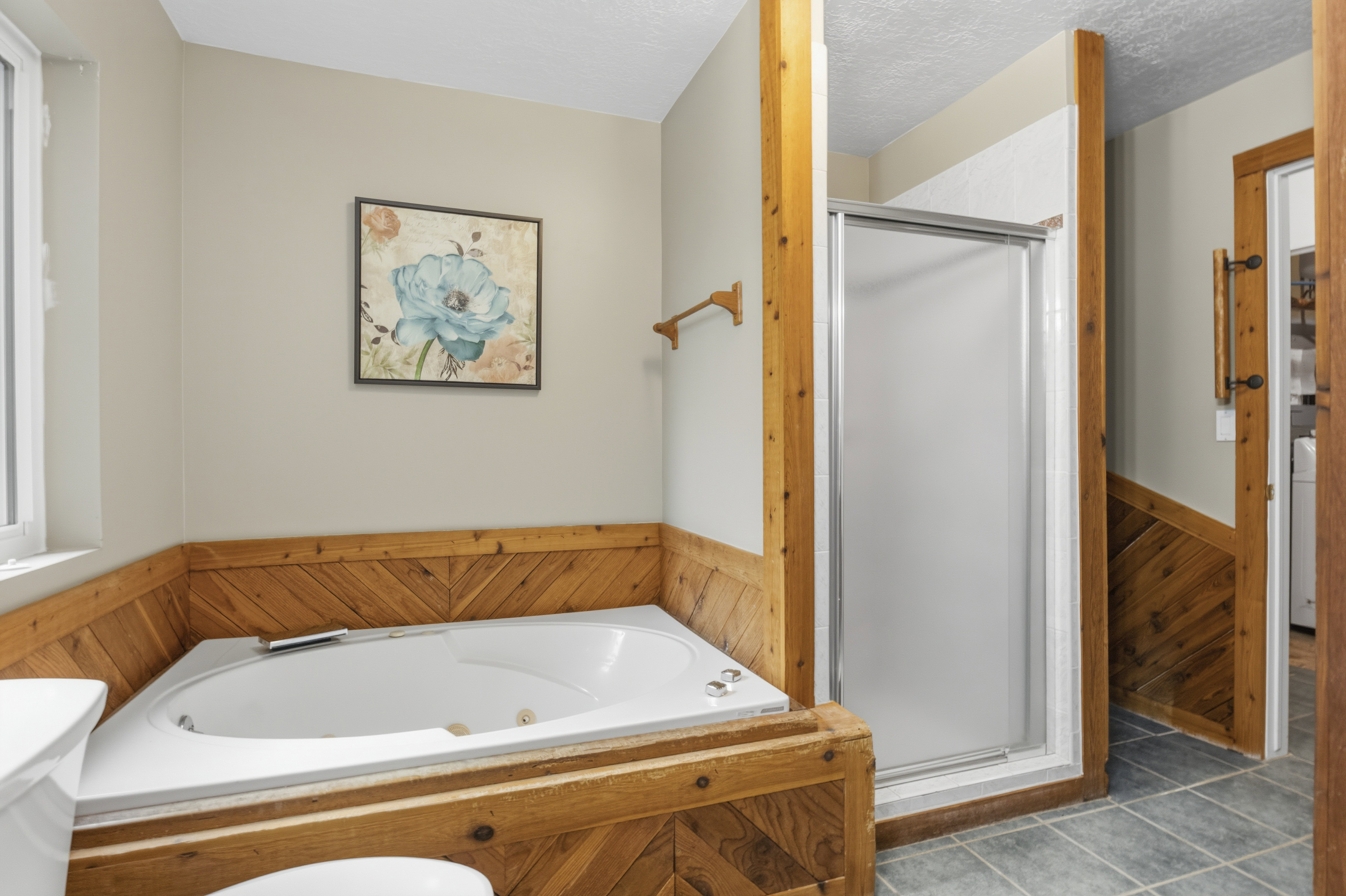 Corner jetted soaking tub featuring wood paneling