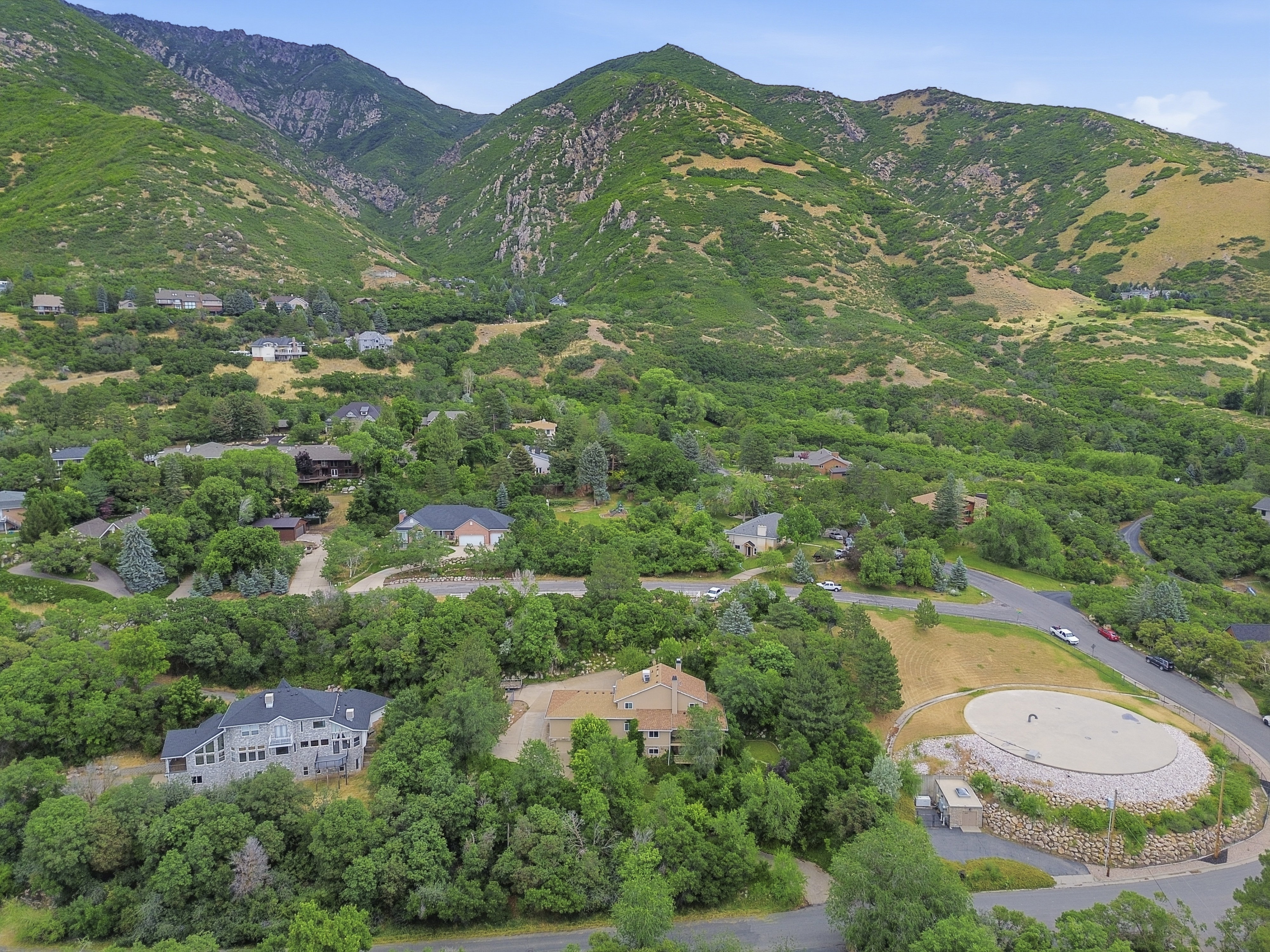 Expansive mountain landscape with diverse foliage and residential properties nestled within the terrain