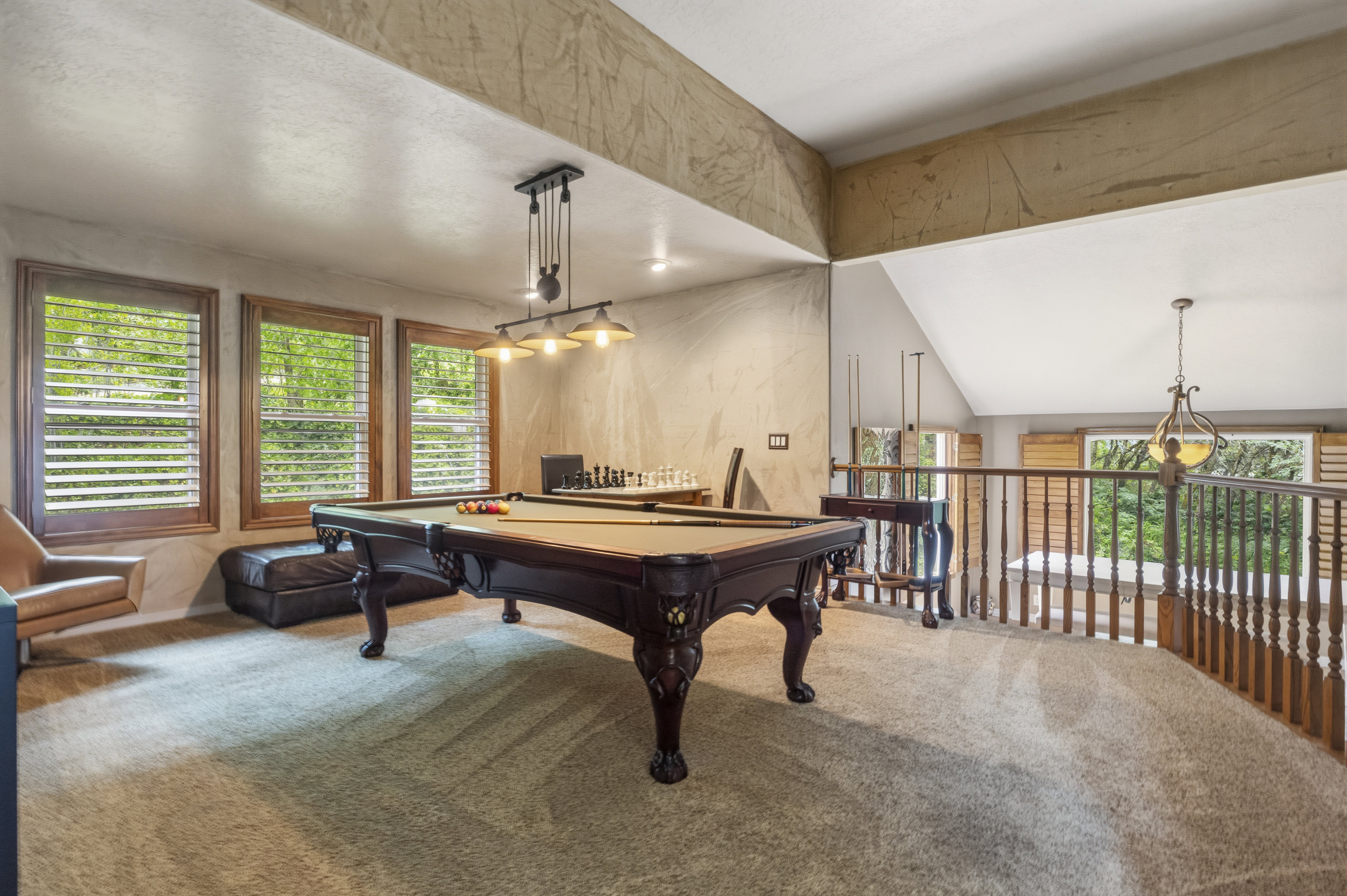 Carpeted upper-level bonus room with a vaulted ceiling and textured wall finishes