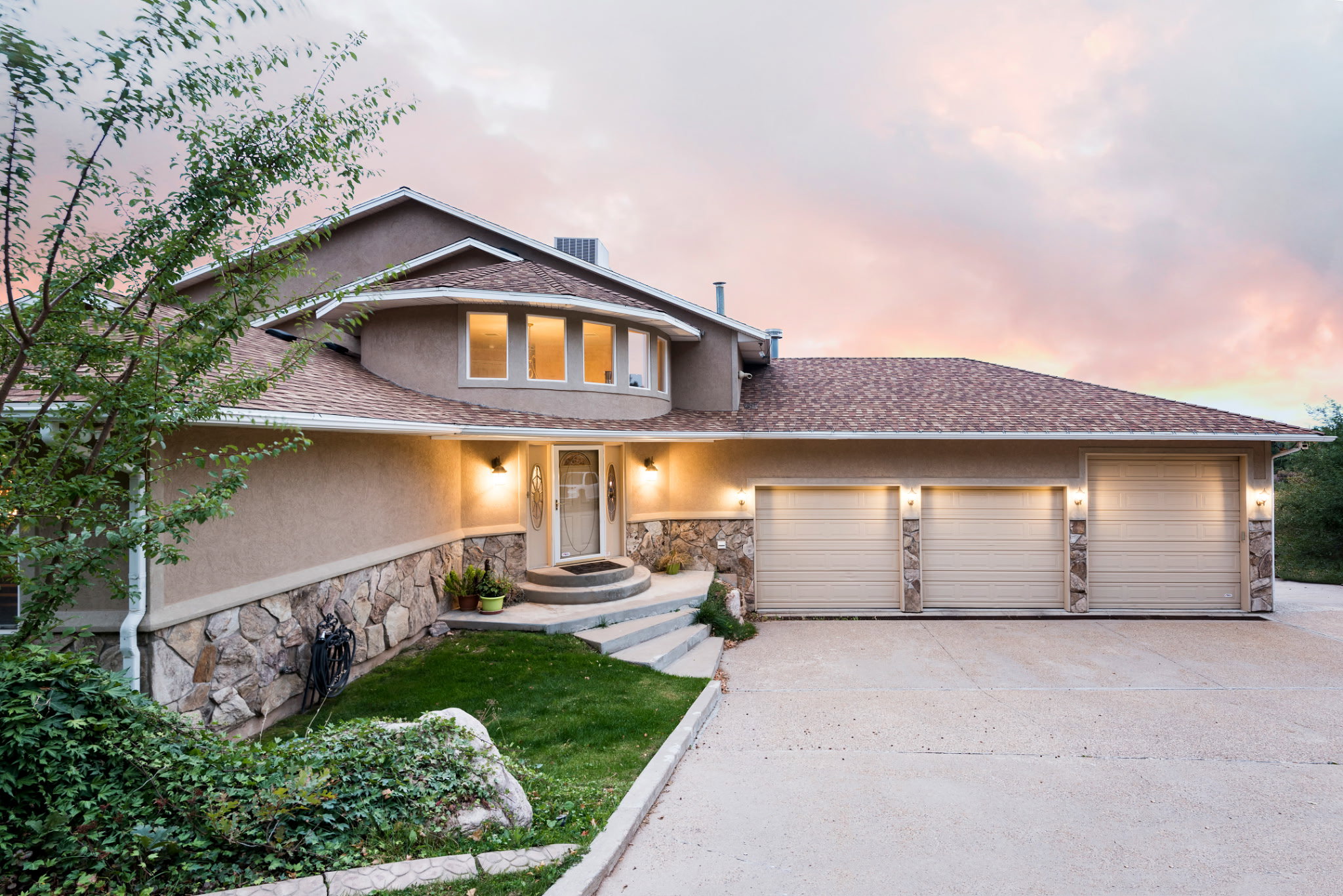 Stucco exterior with stone accents and a multi-level roofline