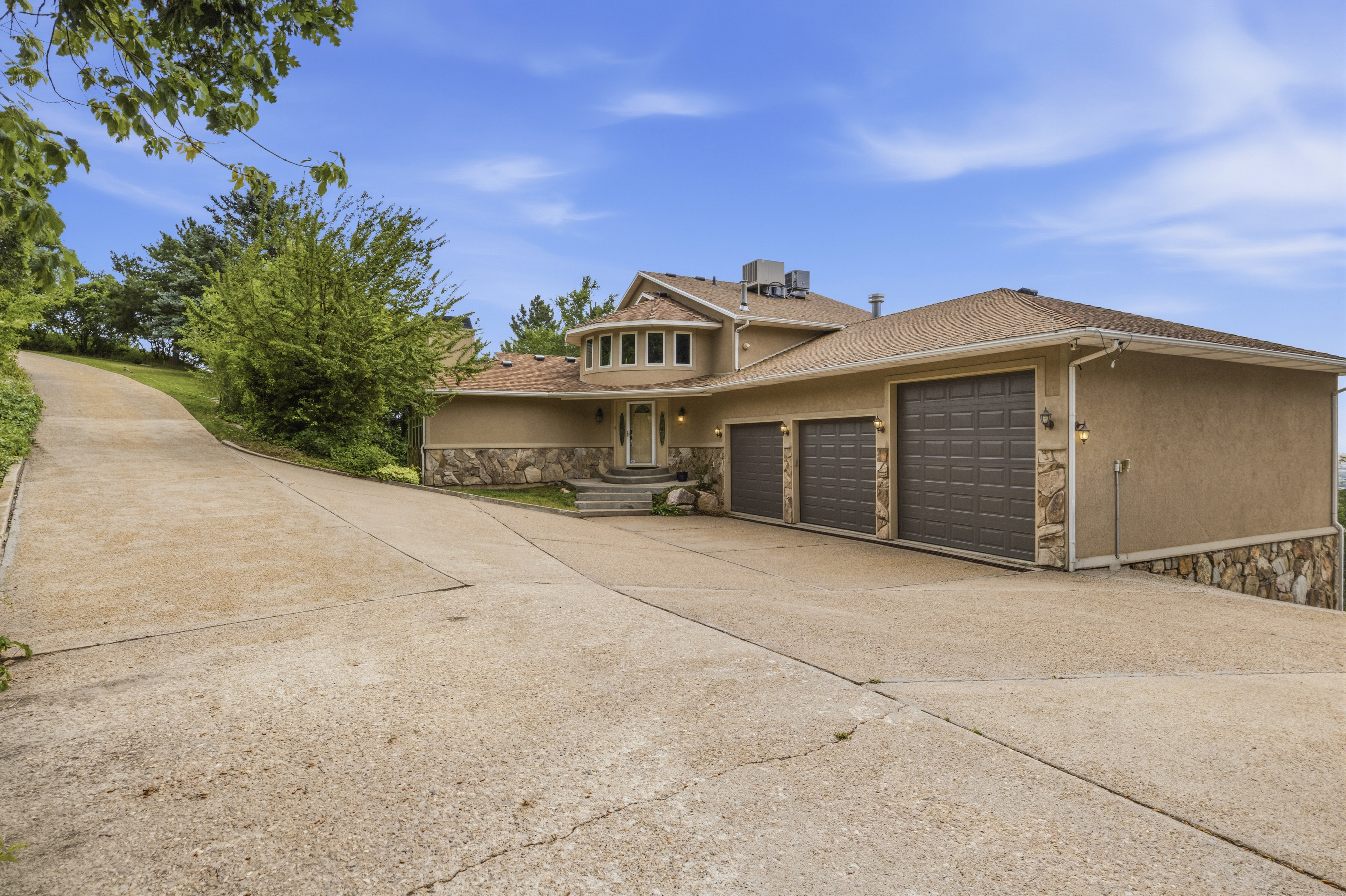 Stucco exterior with stone accents and a multi-level roofline
