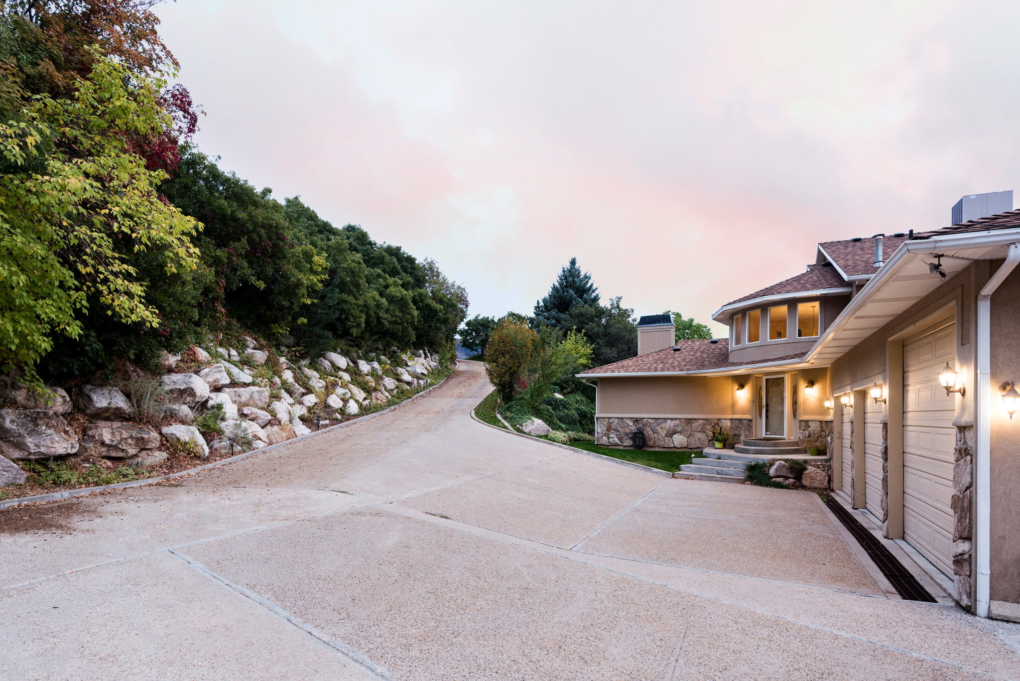 Multi-level home featuring a stucco and stone facade with a circular window array